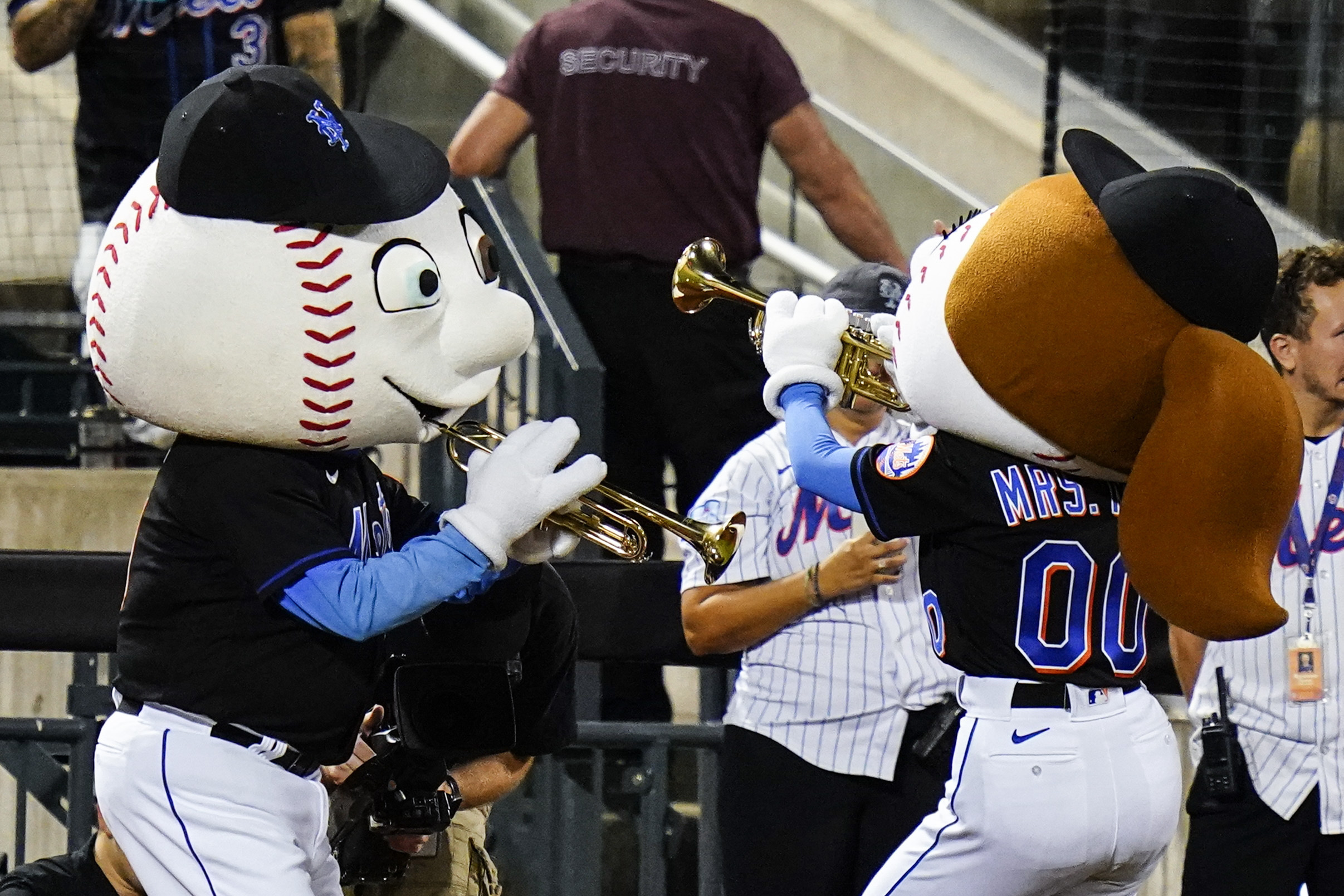 Mr. and Mrs. Met play trumpets as New York Mets reliever Edwin Diaz approaches the pitcher's mound to start the ninth inning of a baseball game against the Philadelphia Phillies, Friday, Aug. 12, 2022, in New York. 
