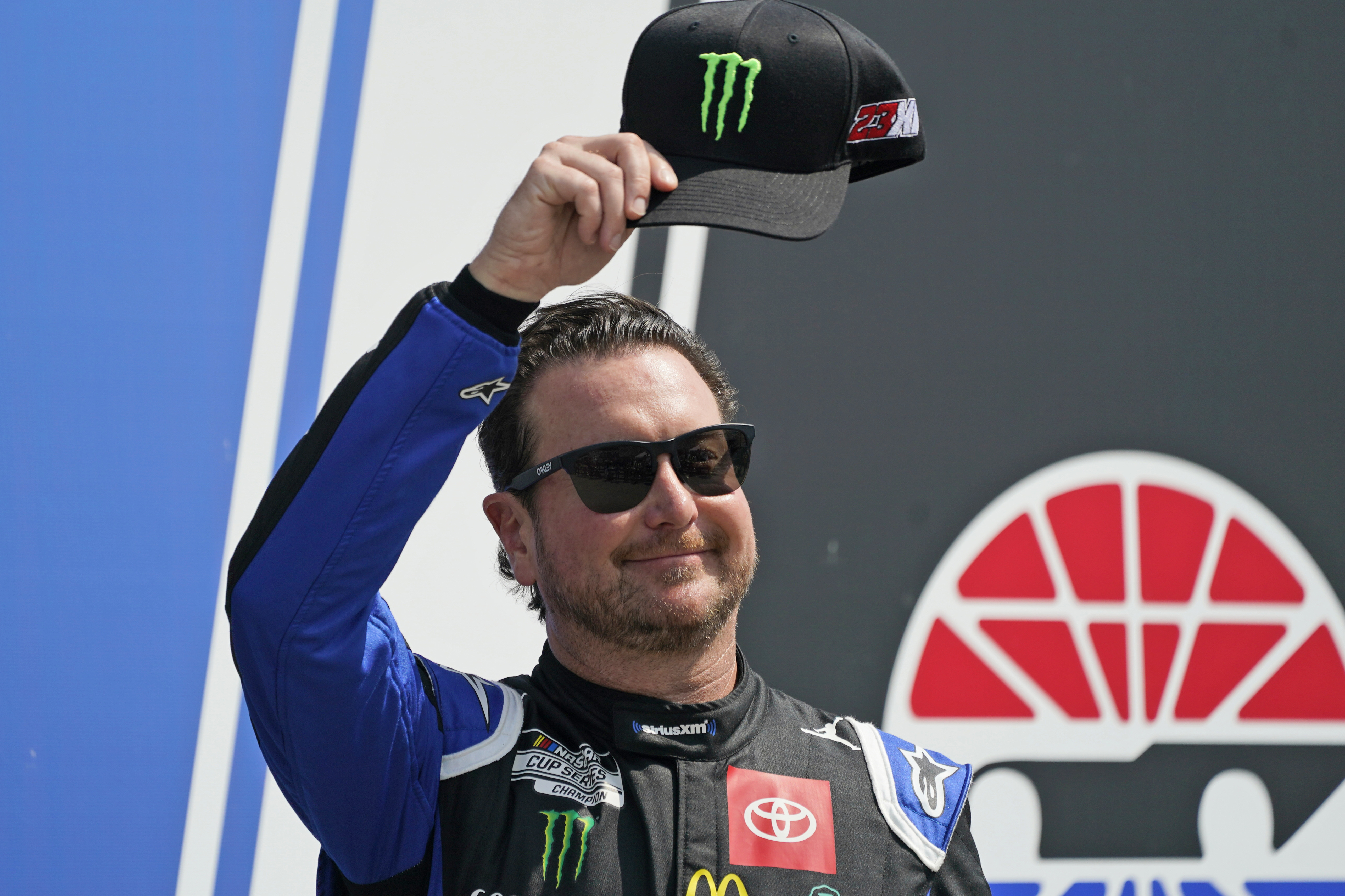 FILE - NASCAR Cup Series driver Kurt Busch tips his cap prior to the NASCAR Cup Series auto race at the New Hampshire Motor Speedway, Sunday, July 17, 2022, in Loudon, N.H. Busch will miss the start of NASCAR’s playoffs with concussion-like symptoms that have sidelined him six weeks, so 23XI Racing on Thursday, Aug. 25, 2022, withdrew the medical waiver that was holding Busch’s spot in the playoffs. 