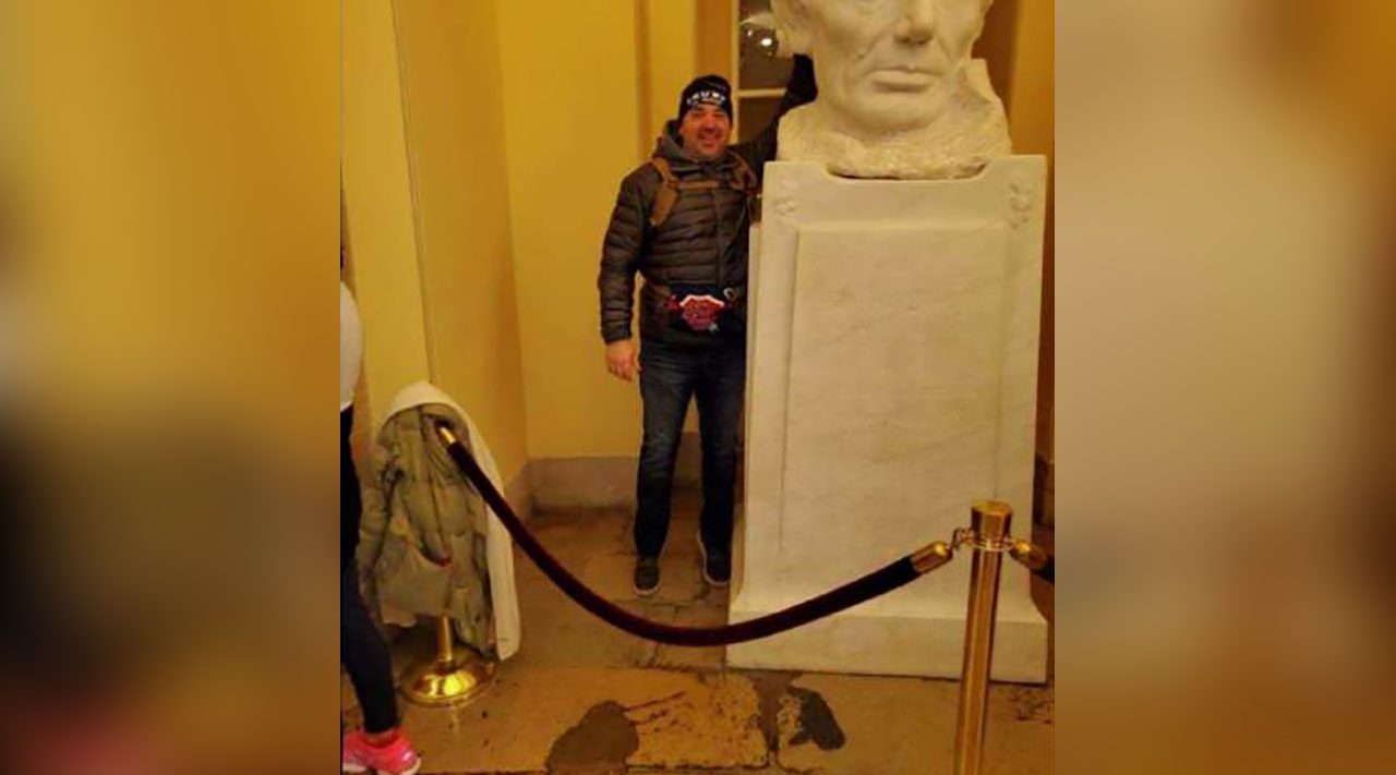 In a screenshot from Michael Hardin's federal complaint, a photo provided to the FBI by a tipster shows a man the tipster says is Hardin posing next to a bust of Abraham Lincoln in the Capitol Crypt on Jan. 6, 2021. Hardin was sentenced for a crime committed during the riot but is now seeking to end his probation early.