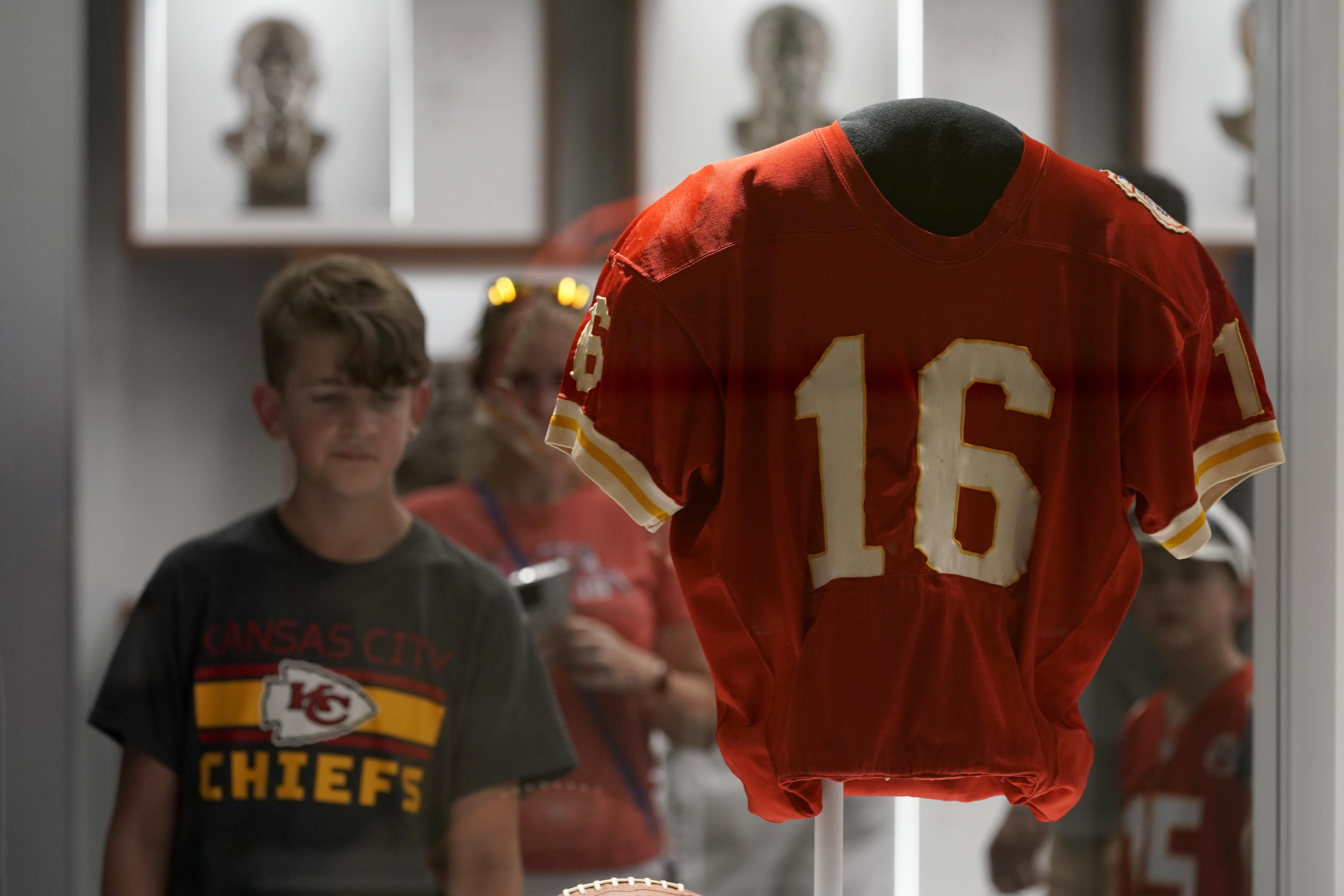 A fan looks at the jersey of former Kansas City Chiefs quarterback Len Dawson before the start of an NFL preseason football game between the Kansas City Chiefs and the Green Bay Packers Thursday, Aug. 25, 2022, in Kansas City, Mo. Dawson, who helped the Kansas City Chiefs to their first Super Bowl title and is in the Pro Football Hall of Fame as a player and broadcaster, died Wednesday at the age of 87. 