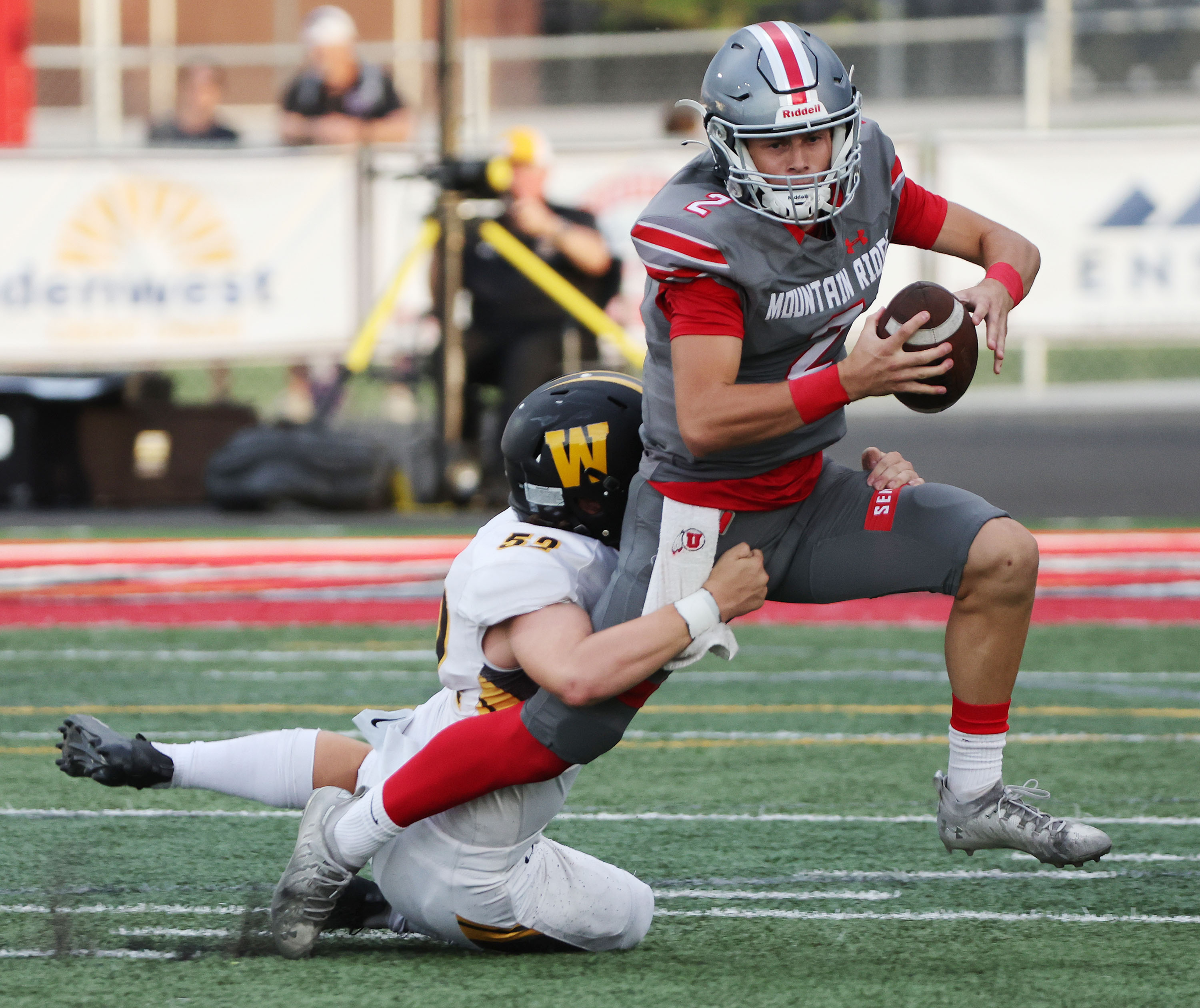 Mountain Ridge QB Jaxson Reiser (2) is sacked by Wasatch’s Ryder Fife (52) in Herriman on Thursday, Aug. 25, 2022.