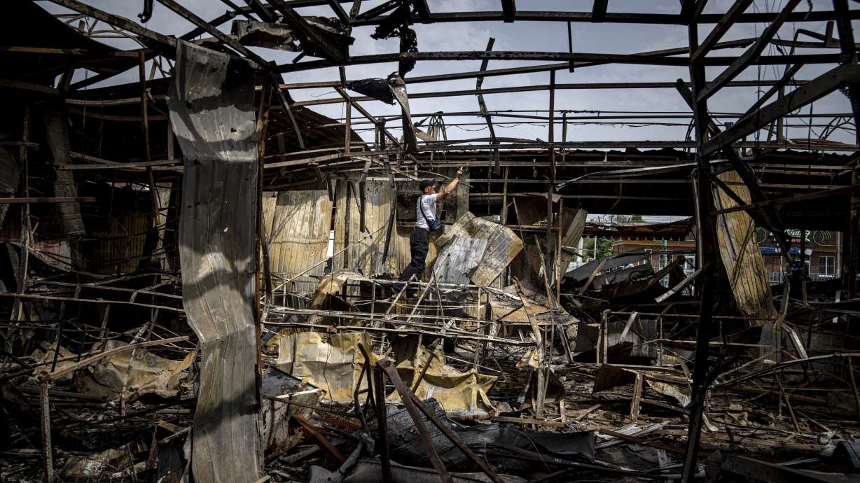 A man collects copper wires from the market which was destroyed after Russian bombardment in Nikopol, Ukraine, Tuesday. The Zaporizhzhia nuclear plant, Europe’s largest, has been occupied by Russian forces since early in the war, and continued fighting nearby has heightened fears of a catastrophe that could affect nearby towns in southern Ukraine or beyond.