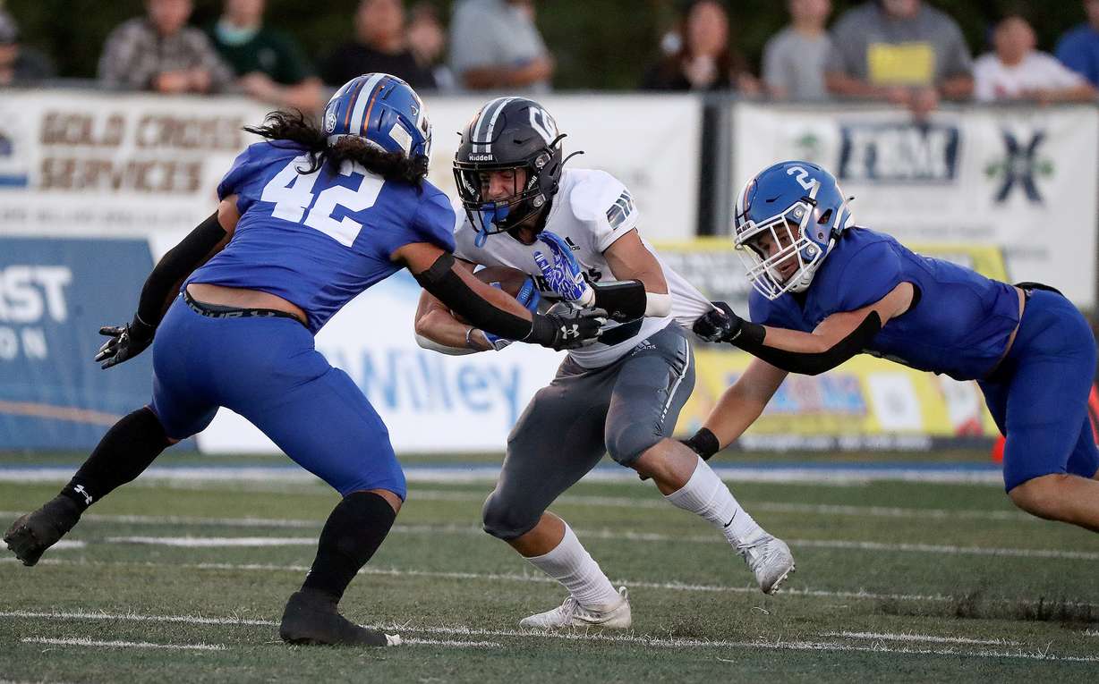 Bingham’s Liahona Lutali (#42) and Kaden Mcbride (#2) tackle Corner Canyon’s Quinn Hale (#5) during a varsity football game at Bingham High School in South Jordan on Friday, Aug. 26, 2022. Corner Canyon won 38-28.