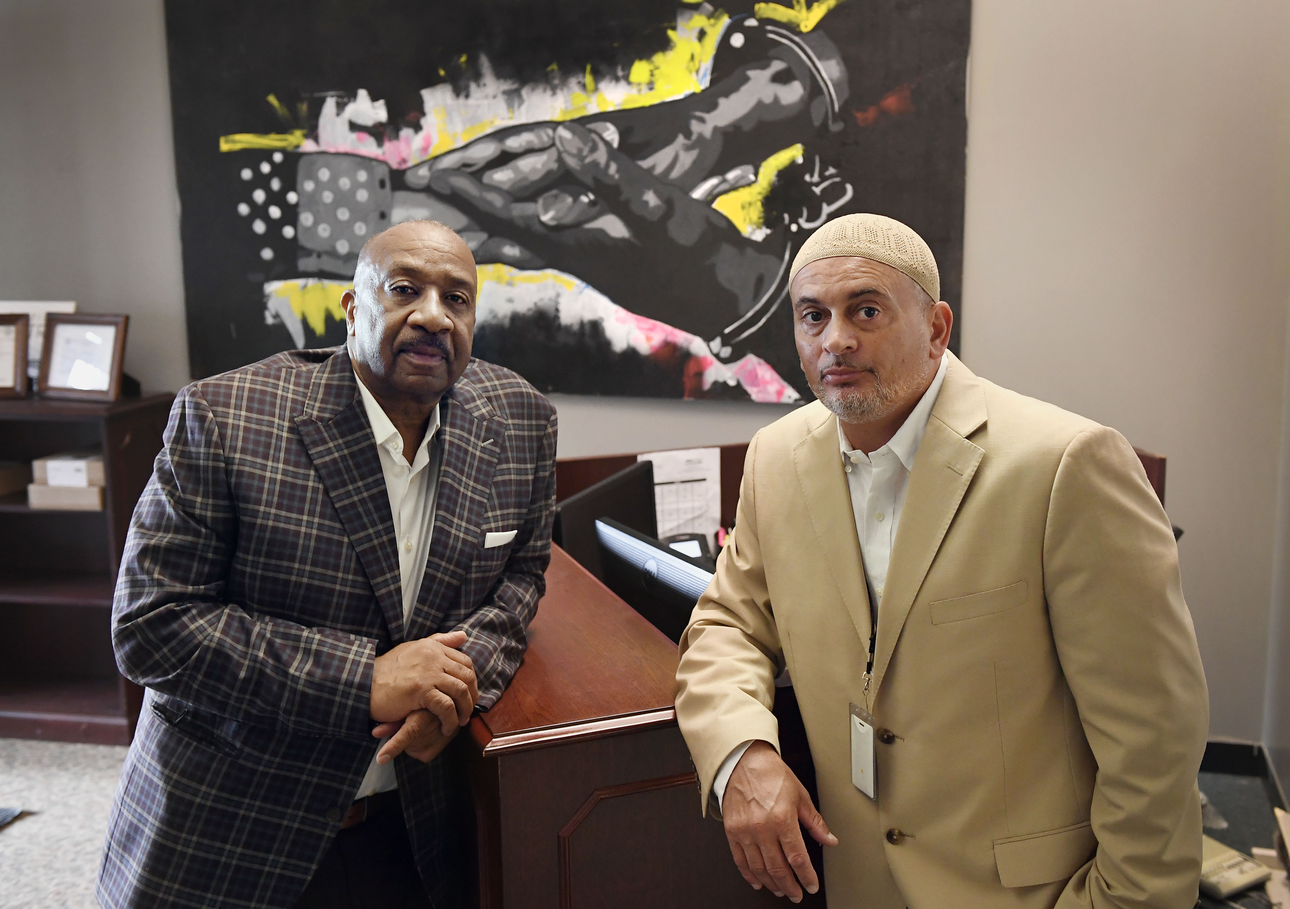 In this Aug. 10 photo, Fred Hodges, left, and Da'ee McKnight at their workplace, Family ReEntry, a reentry support group aiming to break cycles of violence, crime and incarceration in Bridgeport, Conn. Hodges and McKnight are former Connecticut inmates who have been paying for cost of their incarceration. 