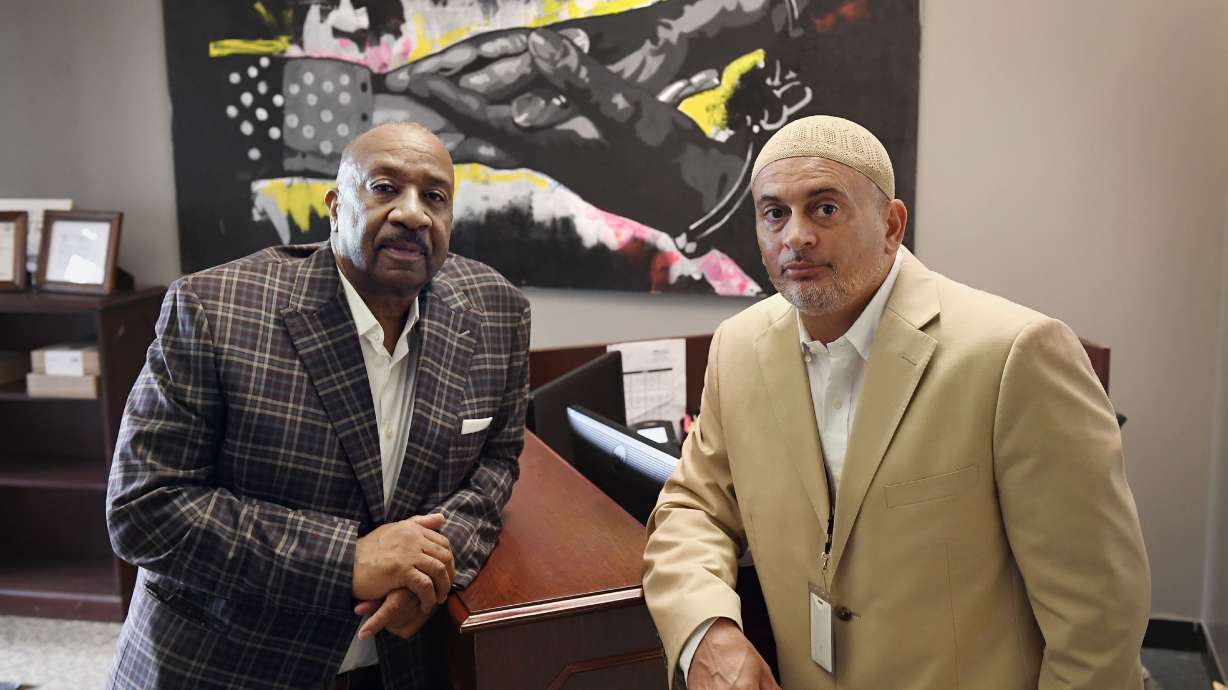In this Aug. 10 photo, Fred Hodges, left, and Da'ee McKnight at their workplace, Family ReEntry, a reentry support group aiming to break cycles of violence, crime and incarceration in Bridgeport, Conn. Hodges and McKnight are former Connecticut inmates who have been paying for cost of their incarceration.