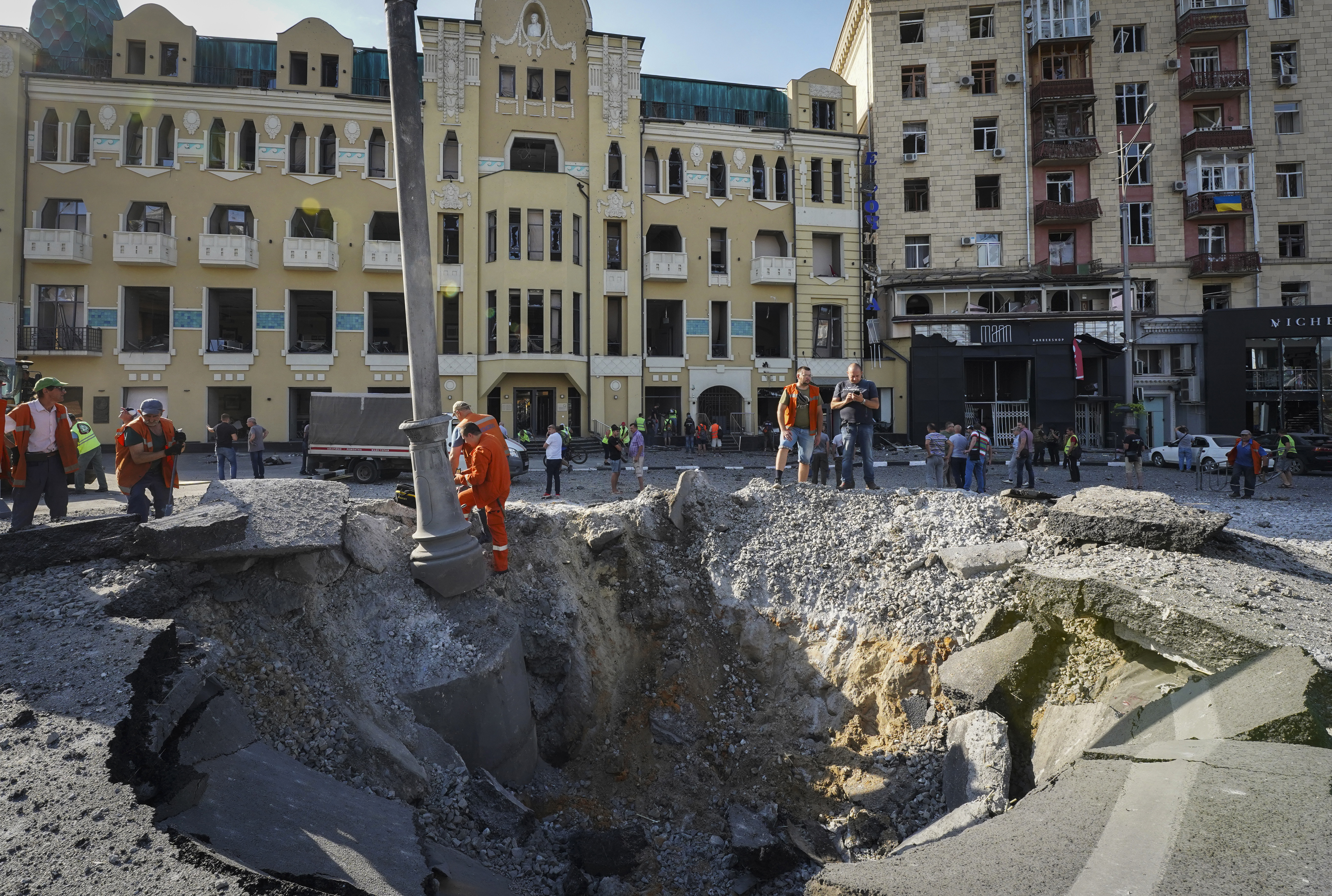 A view of a crater from a night Russian rocket attack, near to damaged buildings in downtown Kharkiv, Ukraine, Saturday.