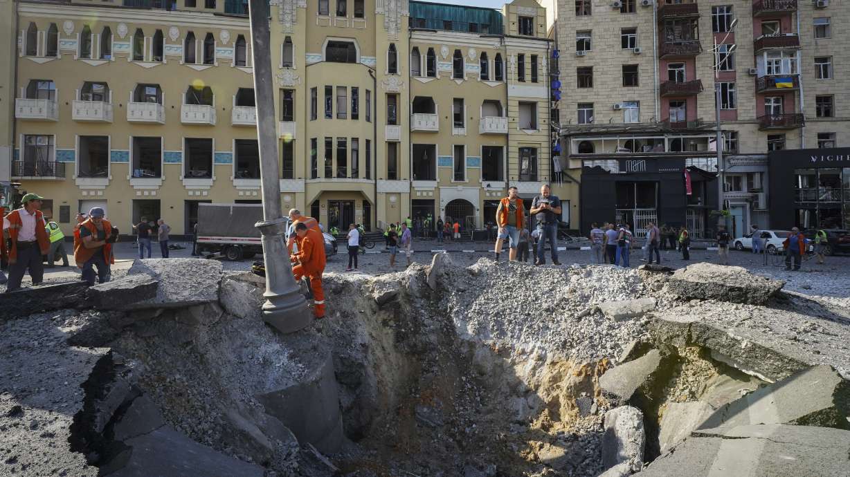A view of a crater from a night Russian rocket attack, near to damaged buildings in downtown Kharkiv, Ukraine, Saturday.