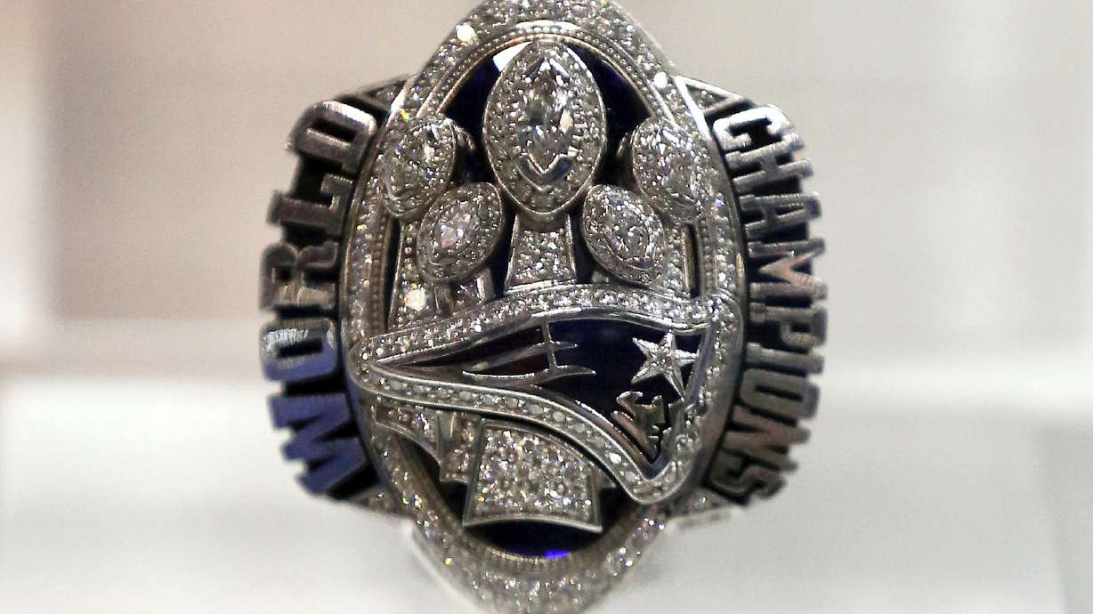 FILE - A New England Patriots Super Bowl LI ring is displayed at the Super Bowl Rings exhibit in Indianapolis, March 1, 2018. A New Jersey man who posed as a former New England Patriots player in order to buy and sell Super Bowl rings that he claimed were gifts to Tom Brady's family has been sentenced to three years in federal prison.