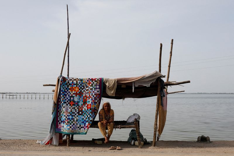 A flood victim takes refuge along a road in a makeshift tent, following rains and floods during the monsoon season in Mehar, Pakistan, Monday.