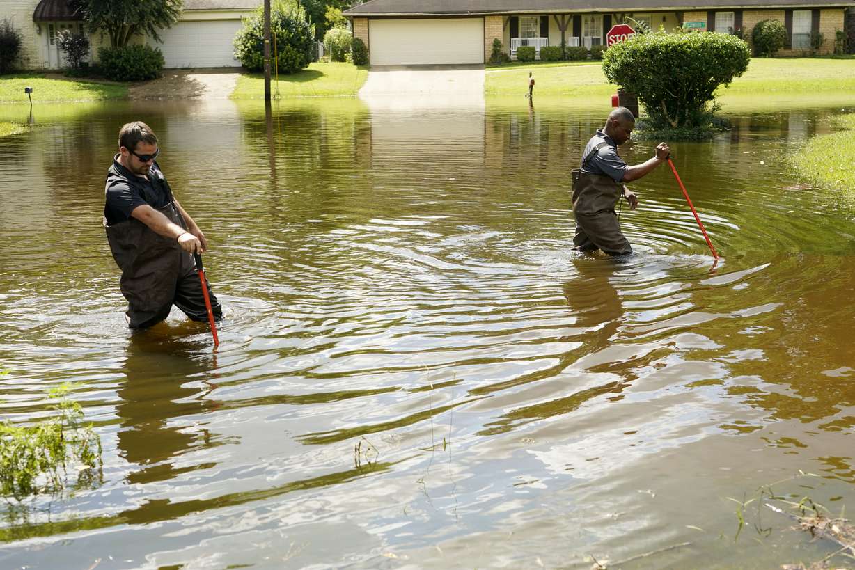 Hinds County Emergency Management Operations deputy director Tracy Funches, right, and operations coordinator Luke Chennault, wade through flood waters in northeast Jackson, Miss., Monday, as they check water levels. Flooding affected a number of neighborhoods that are near the Pearl River.