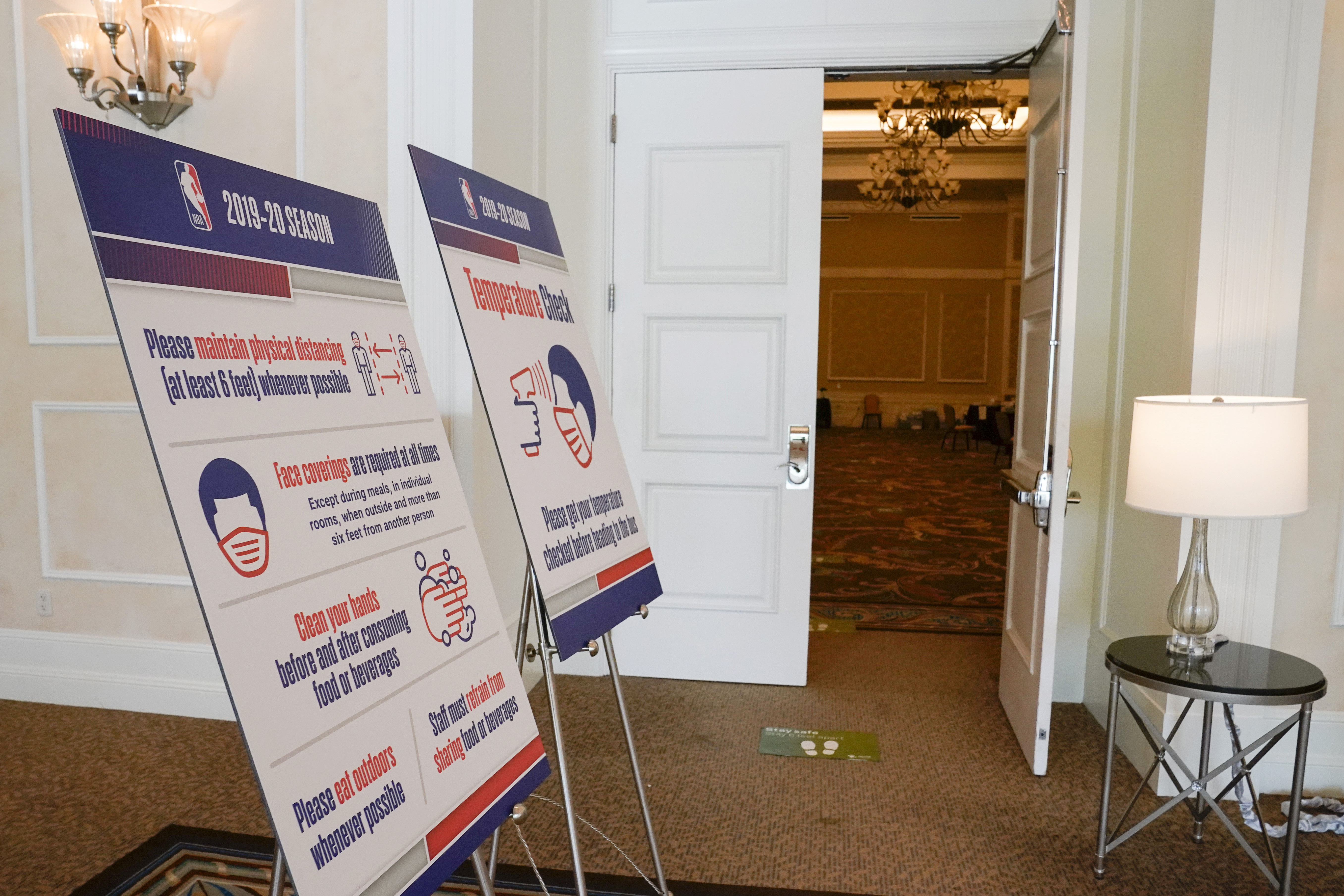 FILE - In this July 29, 2020, file photo, signs lead to an NBA COVID-19 testing site inside ther NBA bubble in Lake Buena Vista, Fla. Unvaccinated NBA players and team personnel must submit to weekly COVID-19 testing this season, the league told its clubs in a memo Tuesday, Aug. 30, 2022. There will be certain exceptions to that mandate, the league said, such as when the unvaccinated person is considered to have been “recently recovered” from COVID-19. 