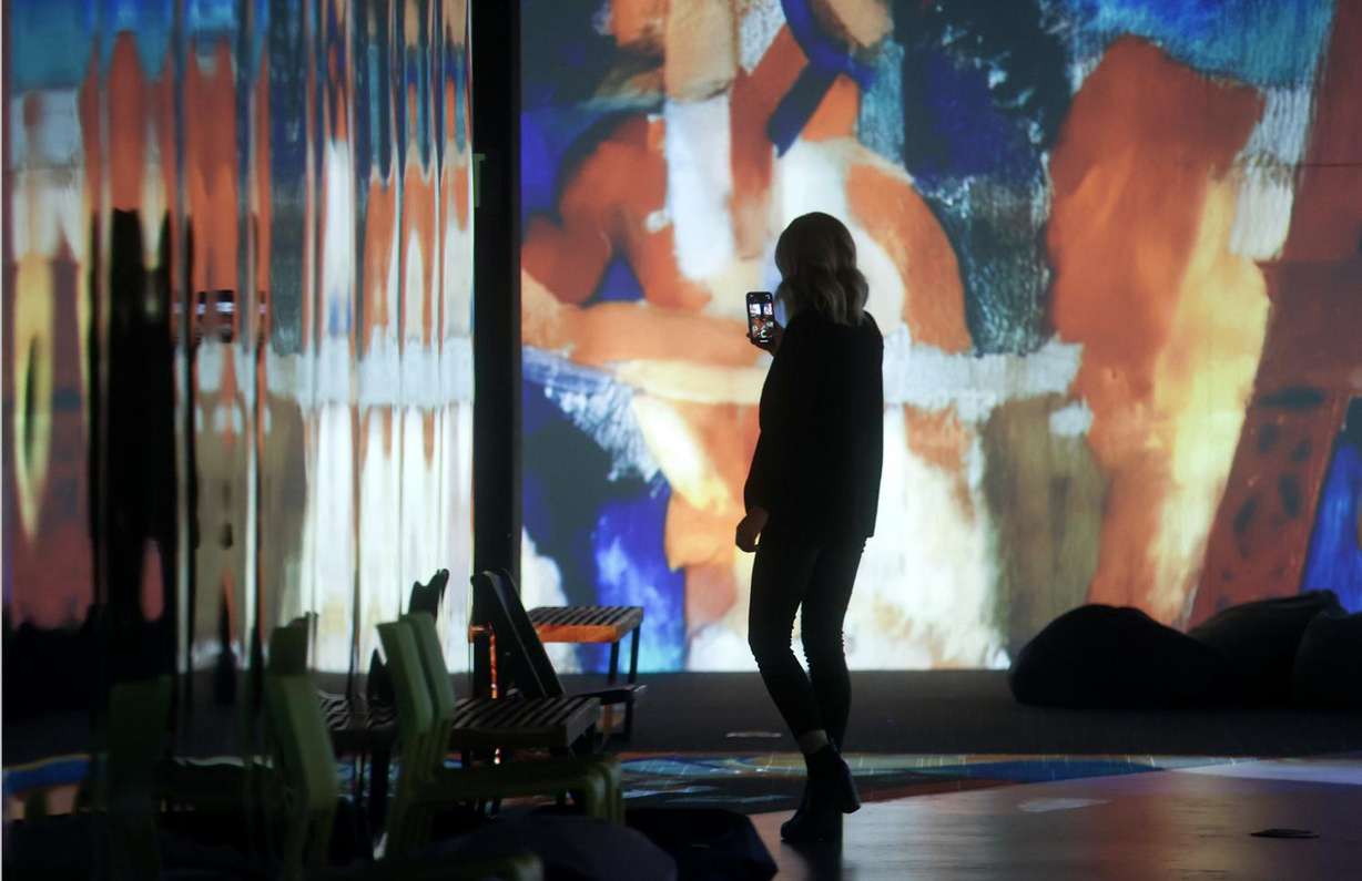 A woman films as she walks through “From Monet to Kandinsky,” an immersive experience offered with Spanish narration, at The Leonardo in Salt Lake City on Tuesday.