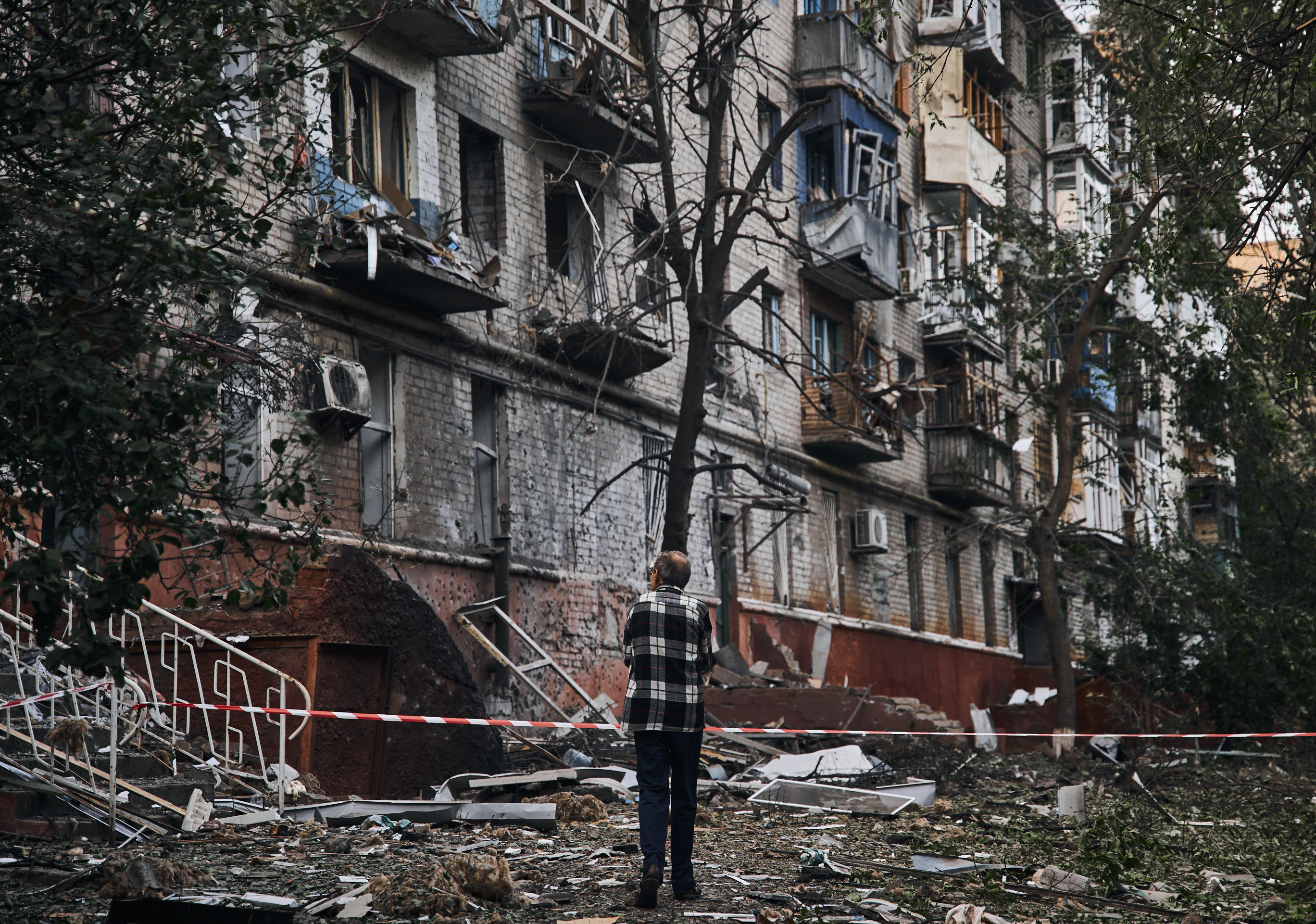 A resident looks at a damaged building after a rocket attack early Wednesday morning, in Kramatorsk, eastern Ukraine.