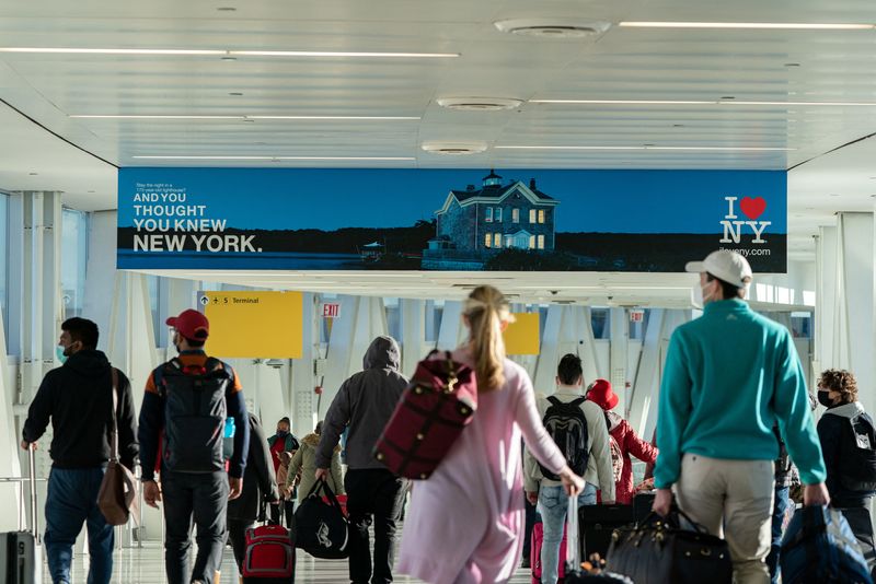 Passengers walk at John F. Kennedy International Airport in Queens, New York City, Dec. 26, 2021. The number of people traveling for the Labor Day holiday weekend is expected to rebound to pre-pandemic levels and possibly set new records in some cases, according to several travel companies.