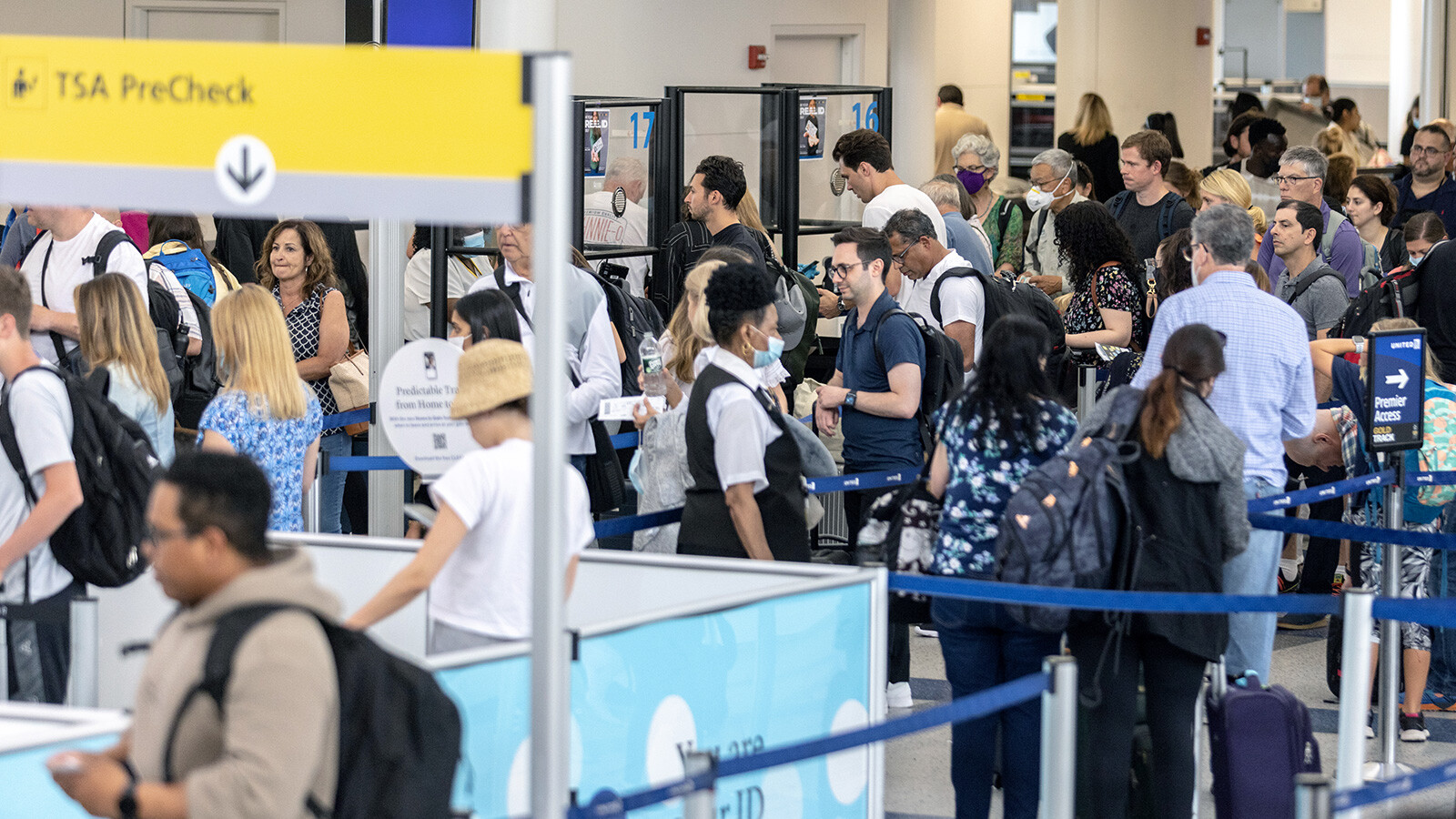 Travelers line up to enter a security checkpoint at Newark Liberty International Airport on July 1 in Newark, New Jersey. Major U.S. airlines have updated their customer service agreements following pressure from the Biden administration to step up consumer rights in the wake of a summer plagued by flight cancellations and delays.