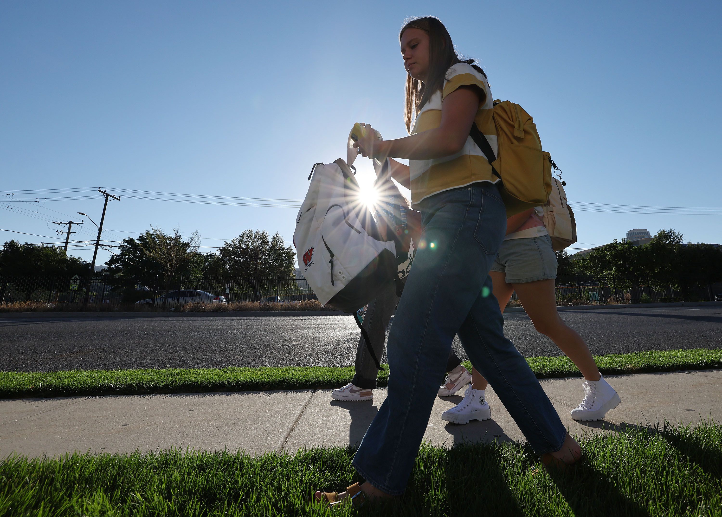 Carol and Audrey Kamerath and their cousin Kate Wright walk to West High School in Salt Lake City on Tuesday.