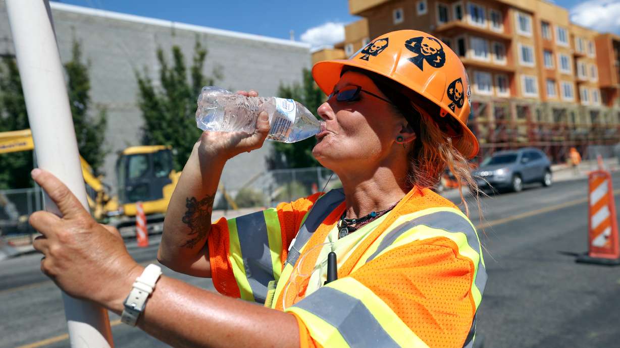 Kristy Nielsen drinks water while flagging traffic for Tempest Enterprises on 1700 South near 300 West in Salt Lake City on Tuesday. Temperatures are expected to hover around 100 degrees in Salt Lake this week, potentially breaking records.