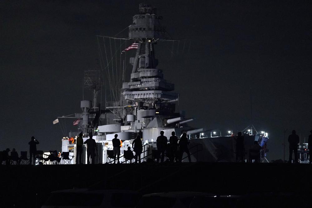 People watch as the USS Texas is moved from the dock Wednesday, in La Porte, Texas. The vessel, which was commissioned in 1914 and served in both World War I and World War II, is being towed down the Houston Ship Channel to a dry dock in Galveston where it will undergo an extensive $35 million repair.