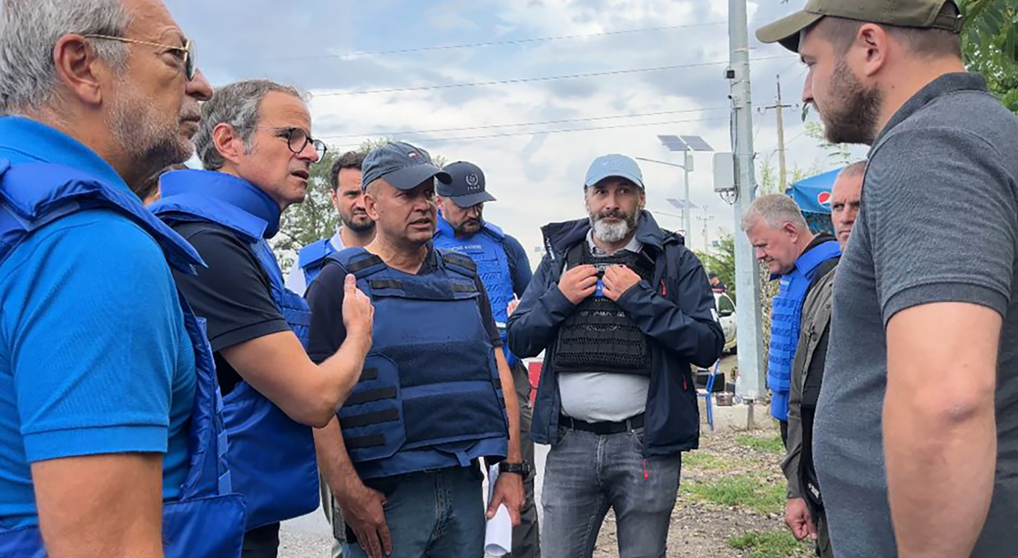 Director General of the International Atomic Energy Agency Rafael Mariano Grossi, second from left, speaks to unidentified authorities as the U.N. agency mission heads to the Zaporizhzhia nuclear power plant, Zaporizhzhia, Ukraine, Thursday.