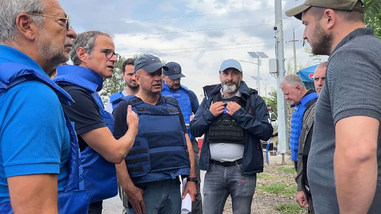 Director General of the International Atomic Energy Agency Rafael Mariano Grossi, second from left, speaks to unidentified authorities as the U.N. agency mission heads to the Zaporizhzhia nuclear power plant, Zaporizhzhia, Ukraine, Thursday.