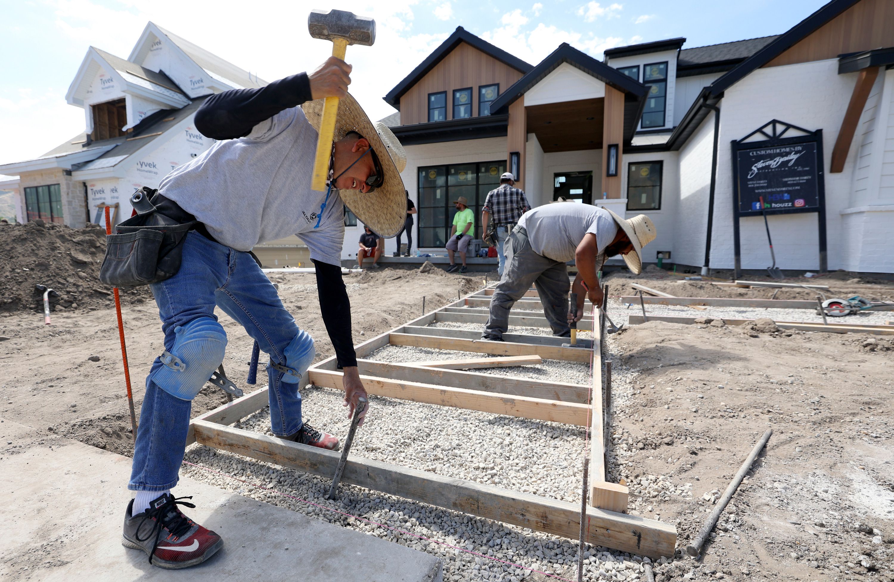 Luis Buroa, with Jones Concrete, helps install a walkway for a Steven Dailey Construction house in Draper on Thursday. It's time to get serious about the U.S. housing supply crisis — a leading issue at the heart of the nation's record high home prices, low rental vacancy rates and affordability problems.