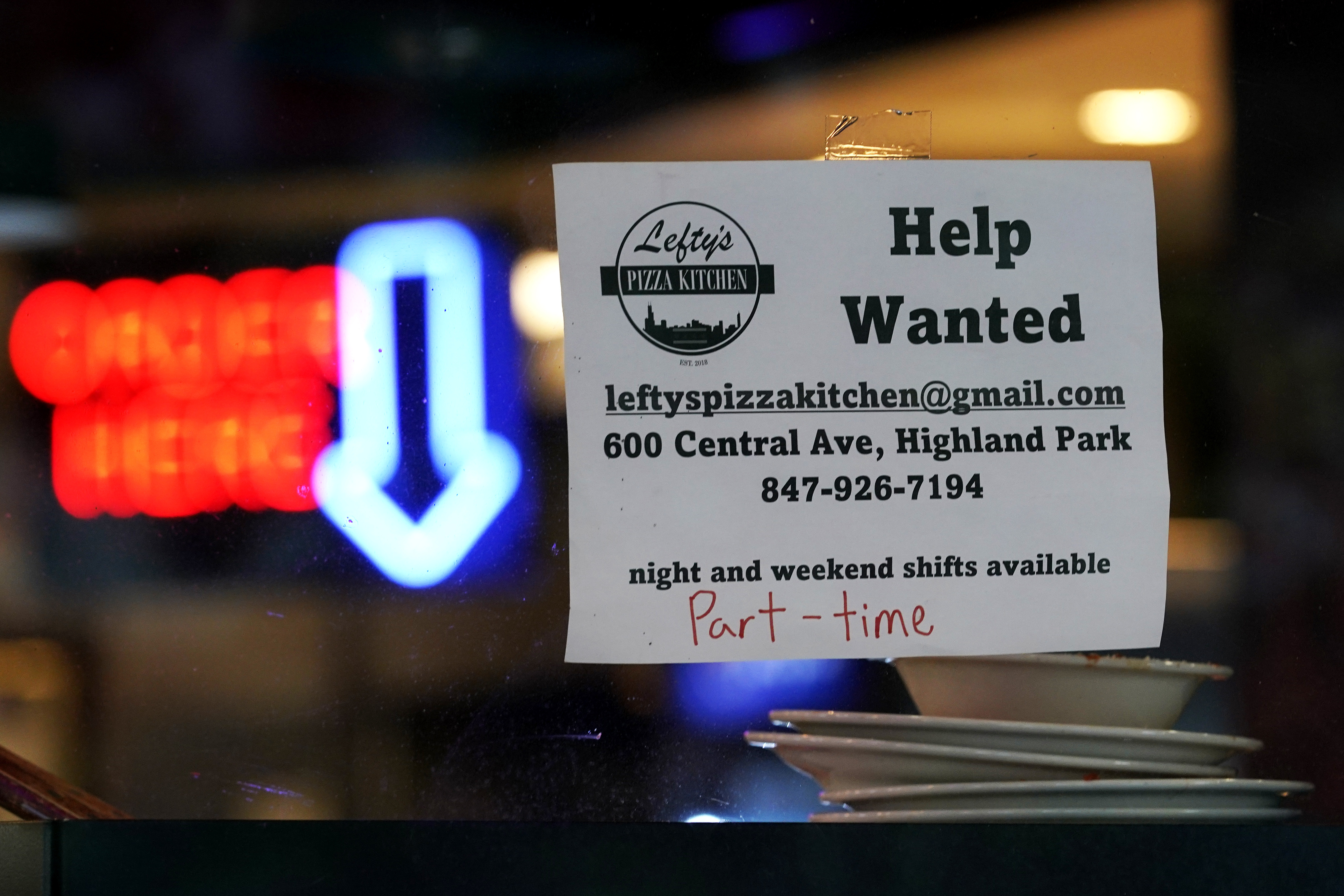 Hiring sign is displayed at a restaurant in Highland Park, Ill., July 14. America's employers slowed their hiring in August in the face of rising interest rates, high inflation and sluggish consumer spending, the Labor Department reported Friday.  