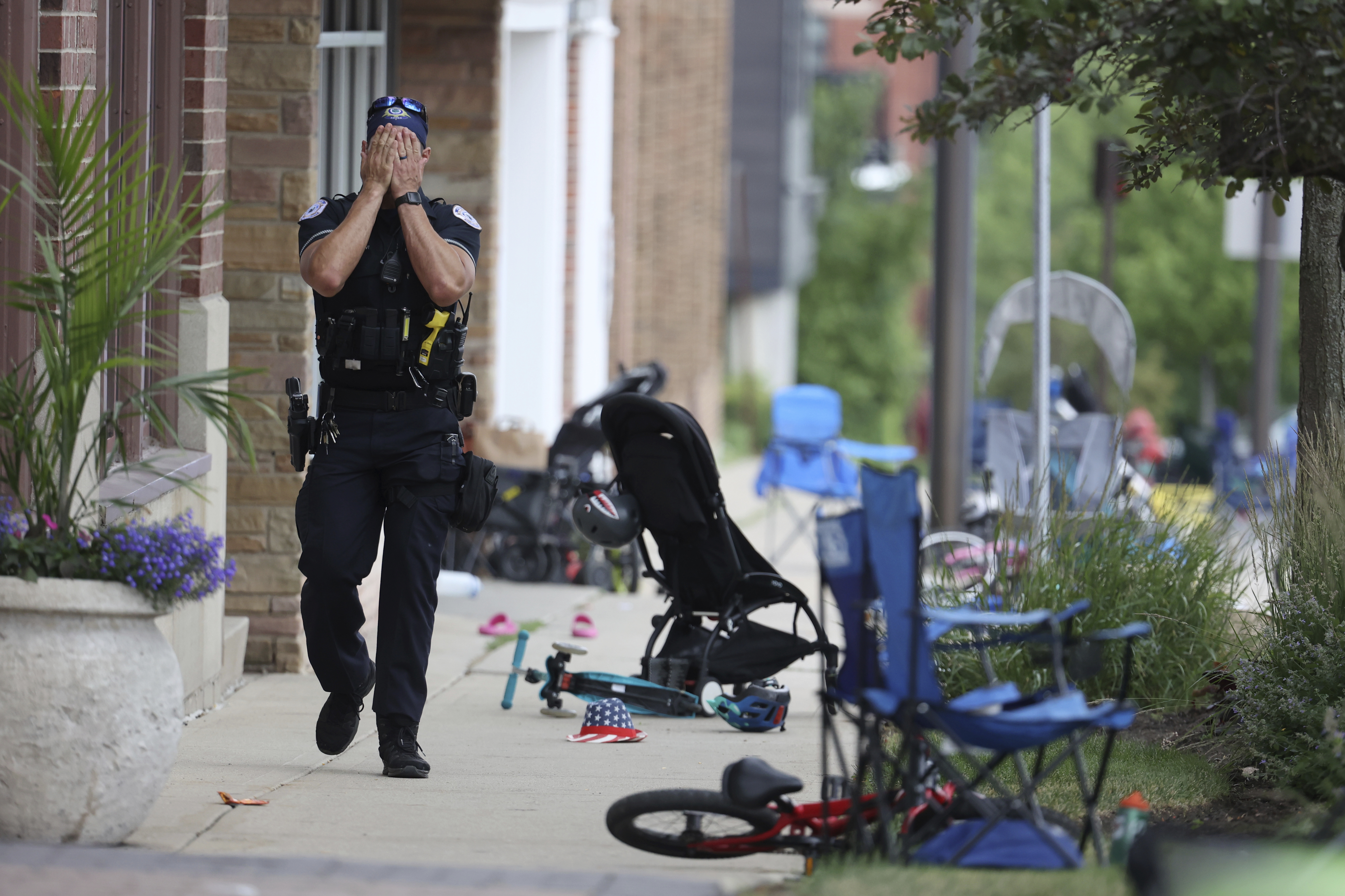 A Lake Forest, Ill., police officer walks down Central Ave in Highland Park, Ill., on July 4, after a shooter fired on the Chicago northern suburb's Fourth of July parade. But amid more than 8,500 shootings resulting in 1,800 deaths since 2020, the law was used there just four times. 