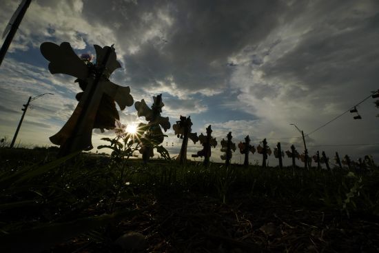 Vehicles pass crosses placed to honor the victims of the shootings at Robb Elementary School, Aug. 25 in Uvalde, Texas. An Associated Press analysis found many U.S. states barely use the red flag laws touted as the most powerful tool to stop gun violence before it happens, a trend blamed on a lack of awareness of the laws and resistance by some authorities to enforce them even as shootings and gun deaths soar.