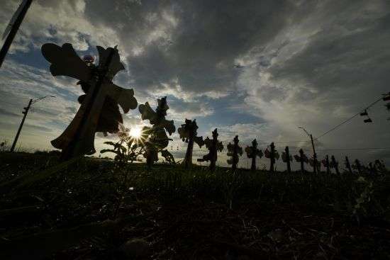 Vehicles pass crosses placed to honor the victims of the shootings at Robb Elementary School, Aug. 25 in Uvalde, Texas. An Associated Press analysis found many U.S. states barely use the red flag laws touted as the most powerful tool to stop gun violence before it happens, a trend blamed on a lack of awareness of the laws and resistance by some authorities to enforce them even as shootings and gun deaths soar.