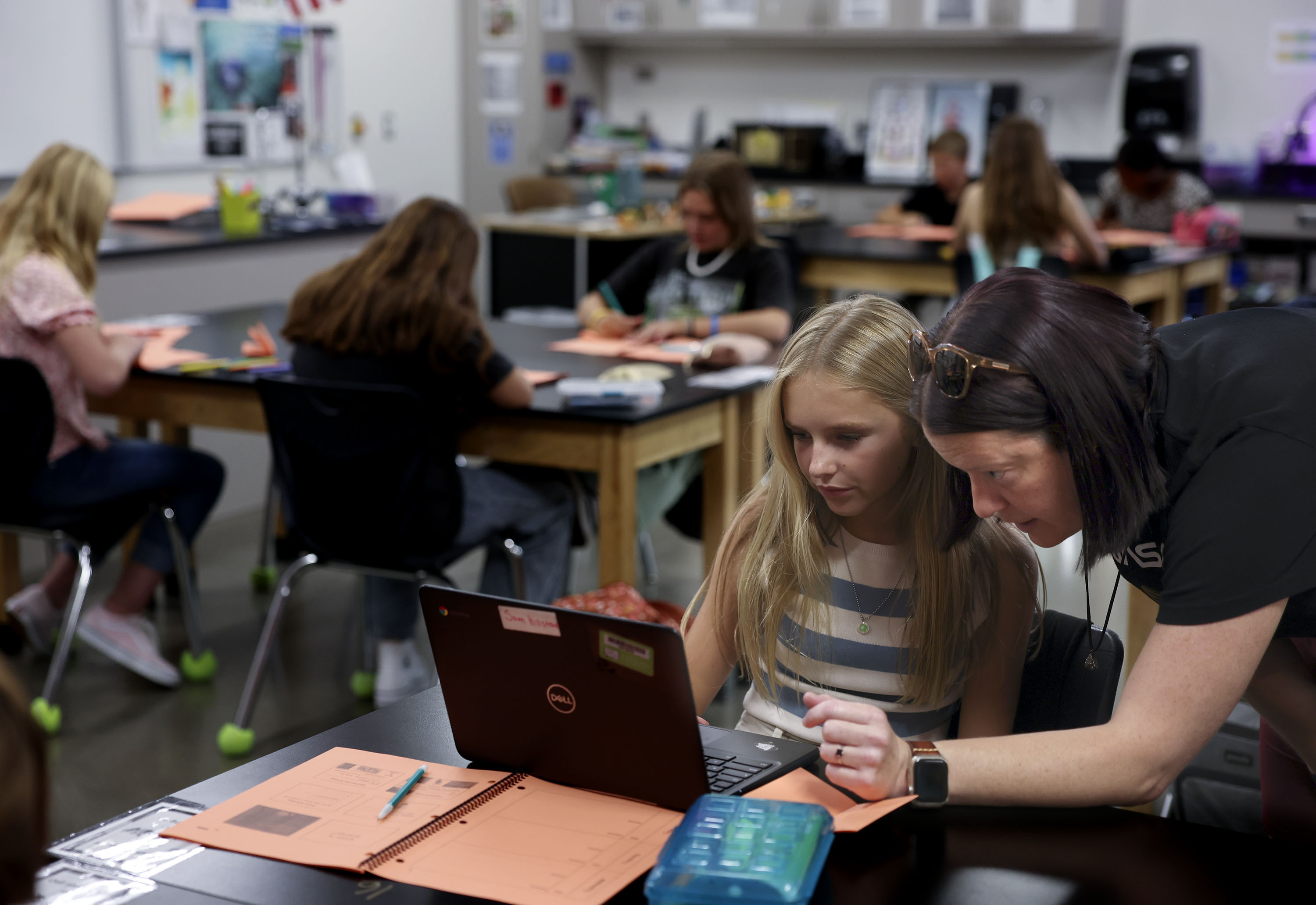 Science teacher Jennifer Muir works with eighth grader Samantha Hillstead at Draper Park Middle School on Friday.