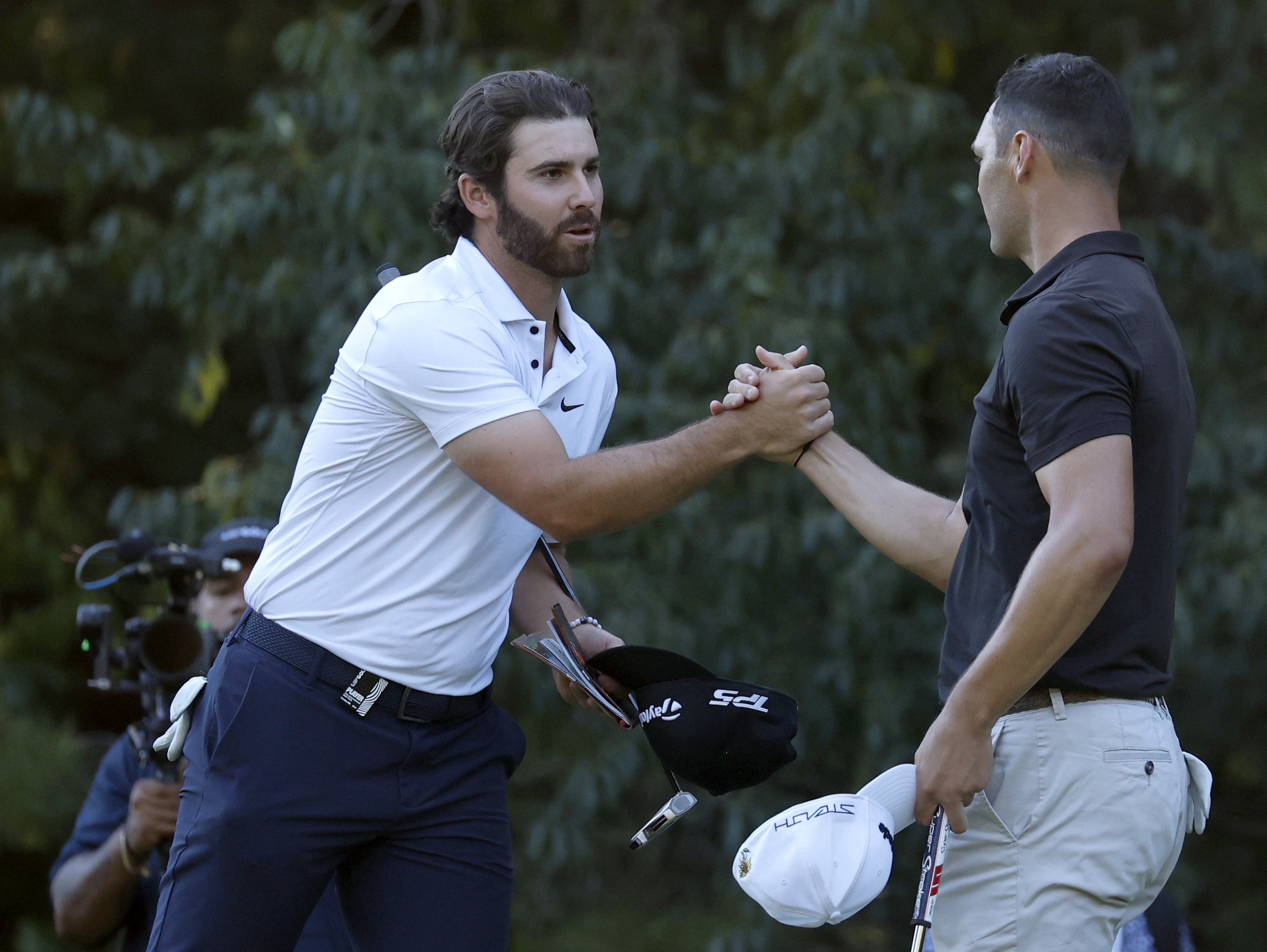 Matthew Wolff, left, shakes hands with Martin Kaymer after they finished the first round of the LIV Golf Invitational-Boston tournament, Friday, Sept. 2, 2022, in Bolton, Mass. 