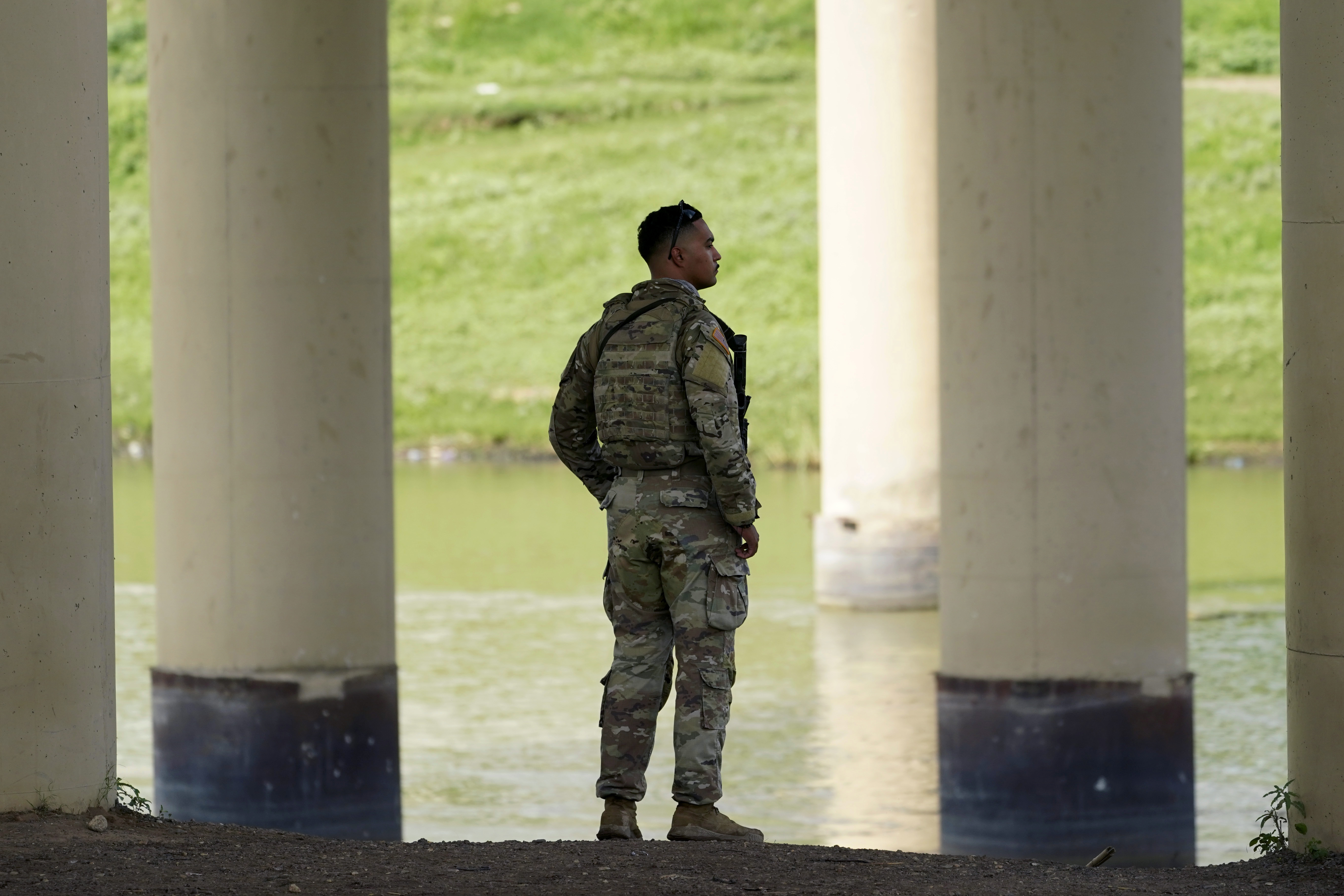 A member of the Texas National Guard looks across the Rio Grande to Mexico from the U.S. at Eagle Pass, Texas, on Aug. 26. At least eight migrants were killed as dozens attempted a hazardous crossing of the Rio Grande near Eagle Pass, Texas, officials said Friday. 