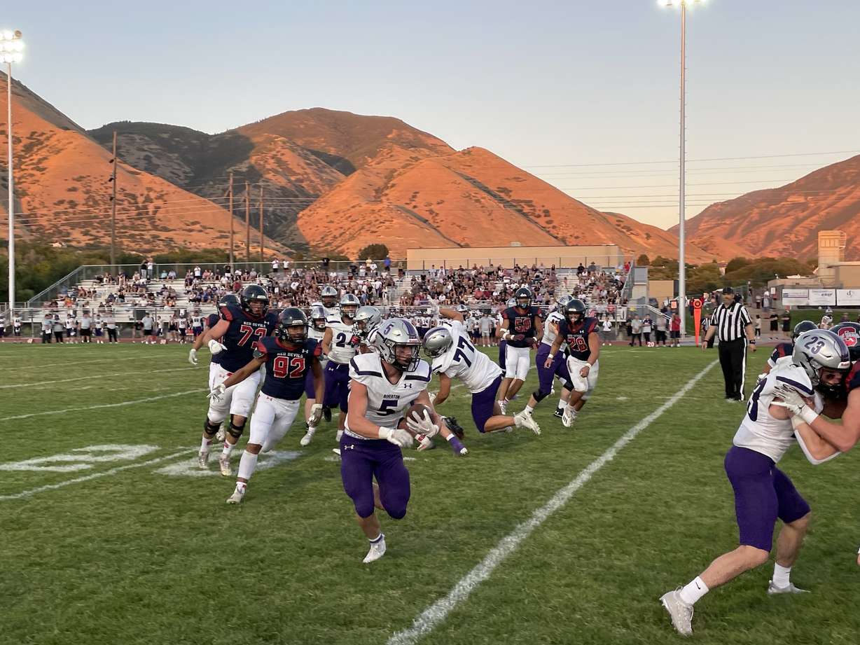 Riverton running back Easton Hicks (5) runs past Springville defenders in a game on Sept. 2, 2022.