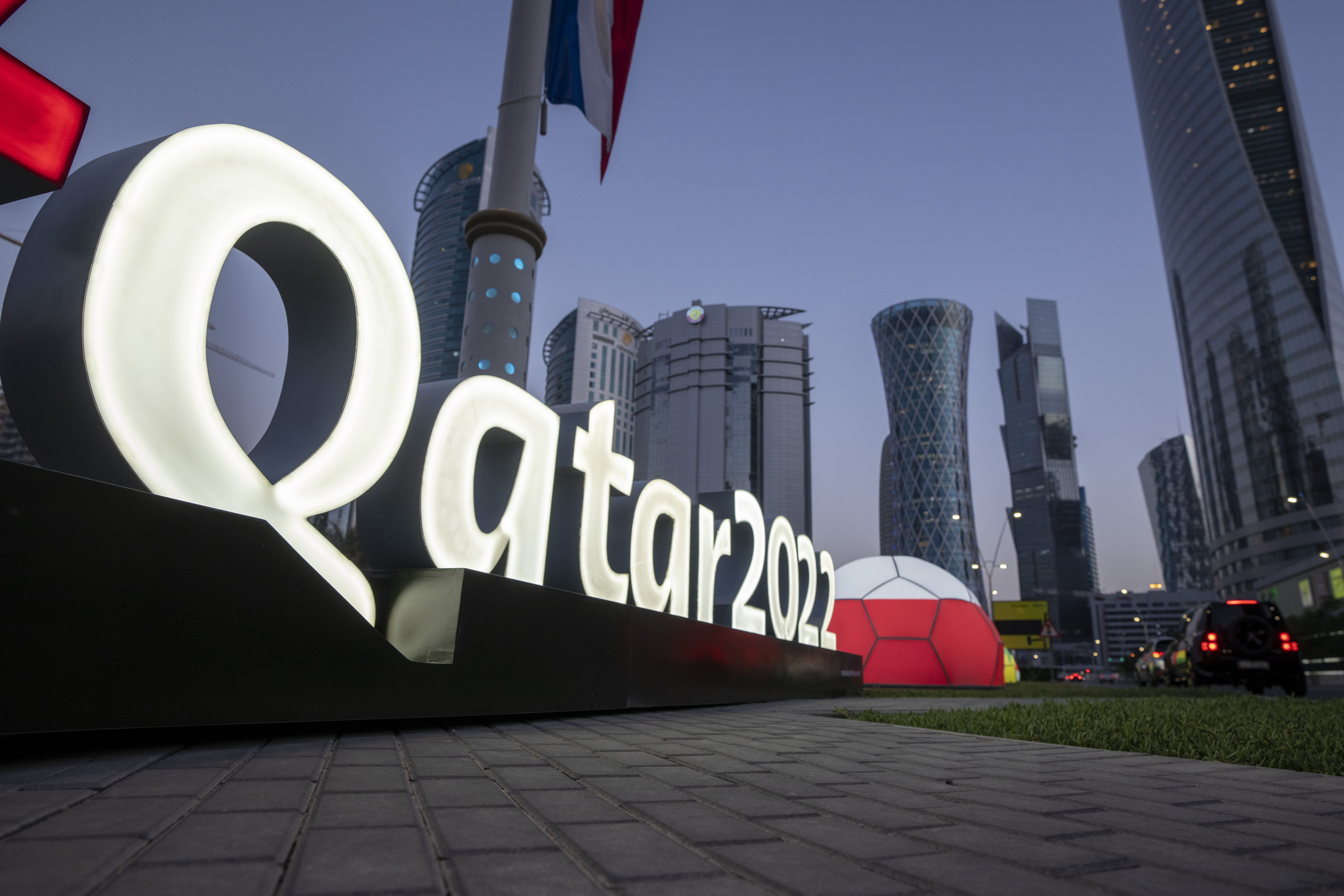 FILE - Branding is displayed near the Doha Exhibition and Convention Center, in Doha, Qatar, March 31, 2022. Qatar recently arrested at least 60 workers who protested going months without pay and deported some of them, an advocacy group said, just three months before Doha hosts the 2022 FIFA World Cup. The move comes as Qatar faces intense international scrutiny over its labor practices ahead of the tournament. The workers' protest on Aug. 14  — and Qatar's reaction to it — could further fuel the concern. 