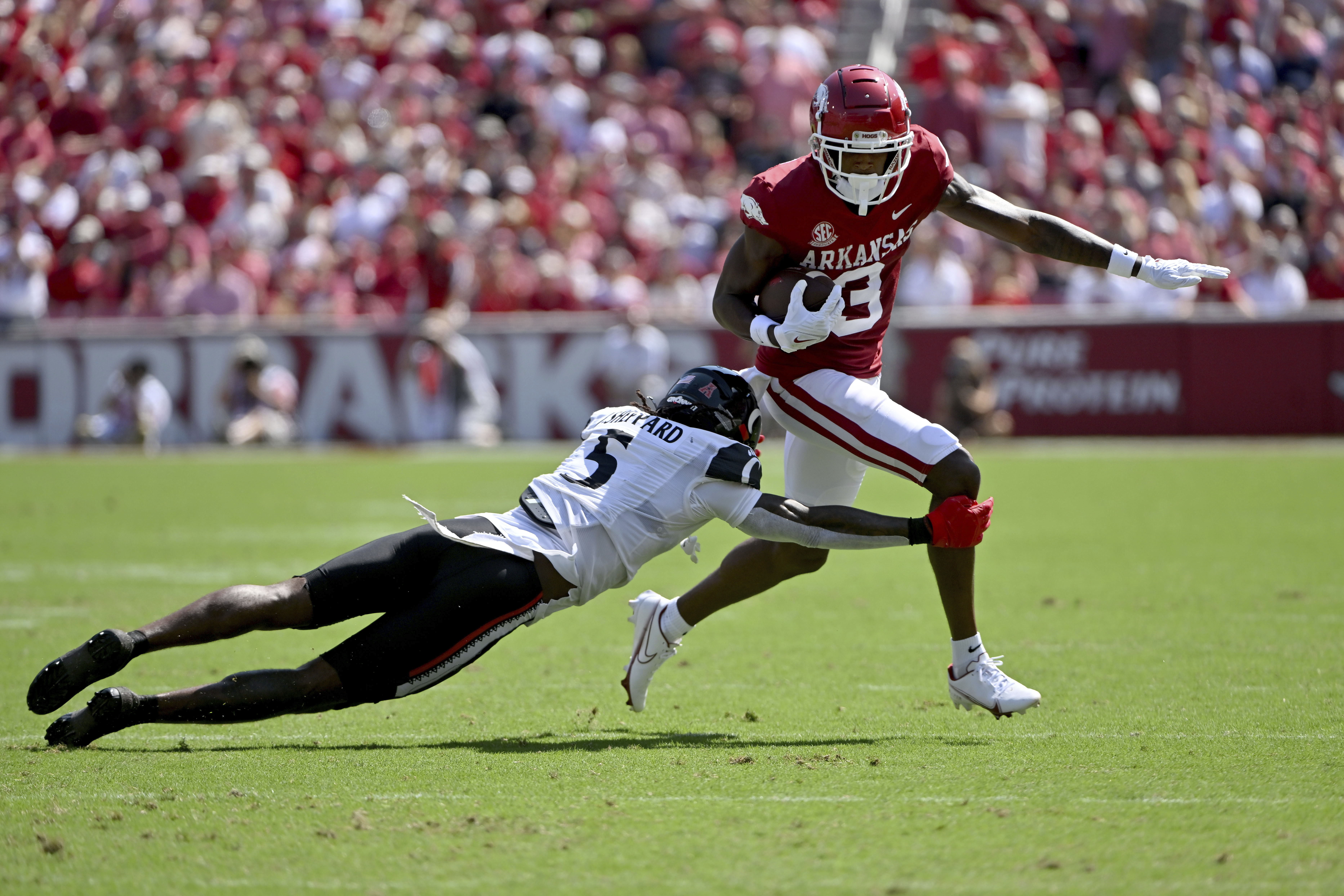 Arkansas wide receiver Matt Landers (3) slips past Cincinnati defensive back Ja'Quan Sheppard (5) as he runs for a gain during the first half of an NCAA college football game Saturday, Sept. 3, 2022, in Fayetteville, Ark. 