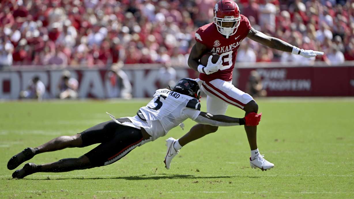 Arkansas wide receiver Matt Landers (3) slips past Cincinnati defensive back Ja'Quan Sheppard (5) as he runs for a gain during the first half of an NCAA college football game Saturday, Sept. 3, 2022, in Fayetteville, Ark.