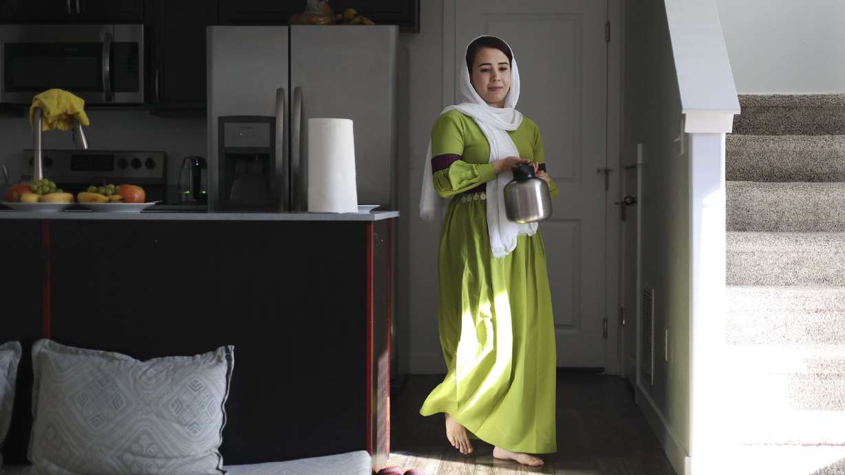 Nazdanah carries a pot of tea in her Herriman home on Wednesday. Nazdanah recently arrived in Utah after being stuck in Afghanistan for almost a year.