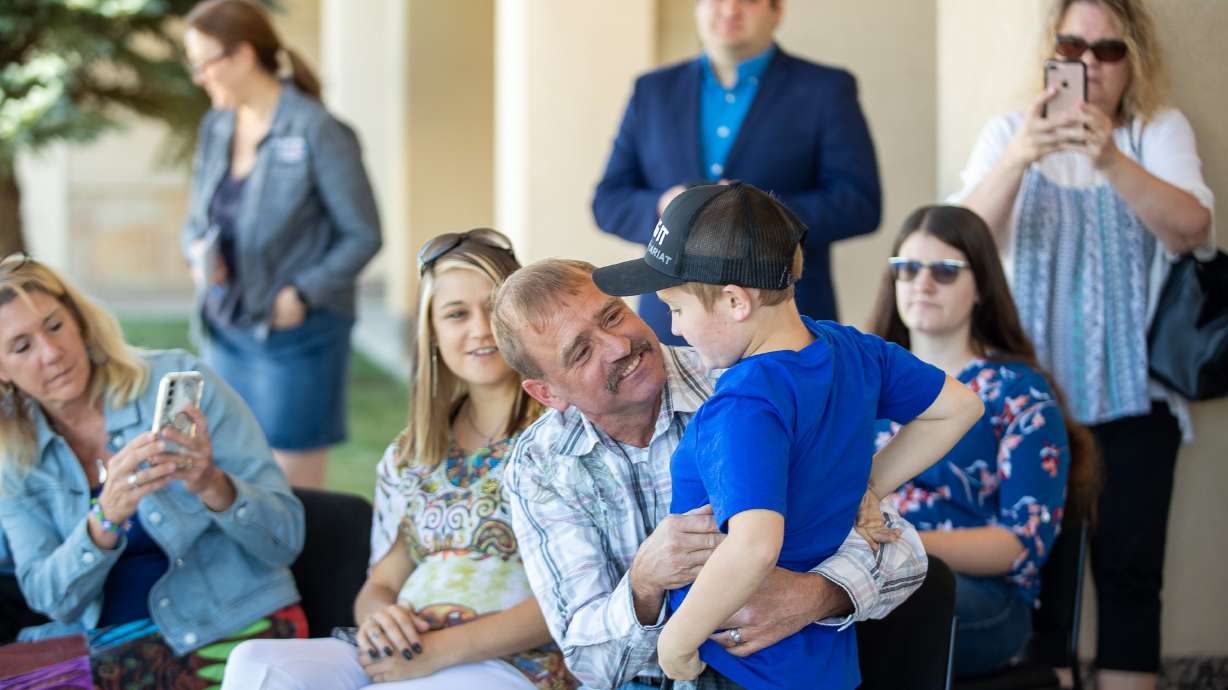 Joe Donnell, center, hugs Paxton Knight, 9, outside of the Summit County Sheriff's Office in Park City on Saturday. Donnell was honored by the Sheriff's Office for rescuing Knight from a submerged car.