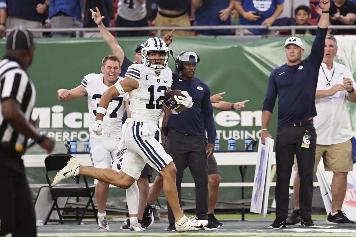 BYU wide receiver Puka Nacua (12) scores on a 75-yard touchdown during the first half of the team's NCAA football game against South Florida on Saturday, Sept. 3, 2022, in Tampa, Fla.