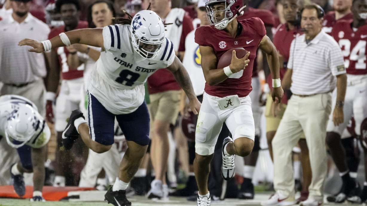 Alabama quarterback Bryce Young, front right, runs with the ball against Utah State defensive lineman Hale Motu'apuaka (8) during the first half of an NCAA college football game Saturday, Sept. 3, 2022, in Tuscaloosa, Ala.