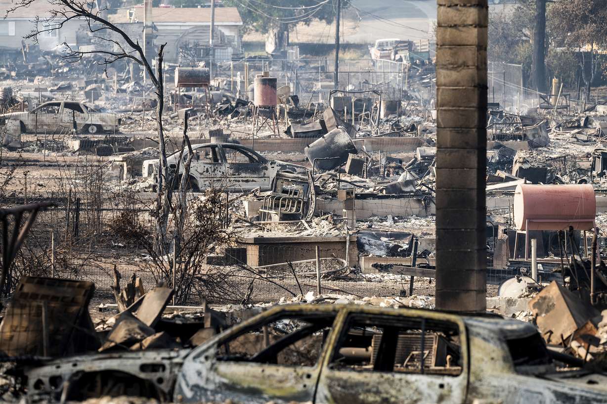 Homes and vehicle destroyed by the Mill Fire line Wakefield Avenue on Saturday, in Weed, Calif.