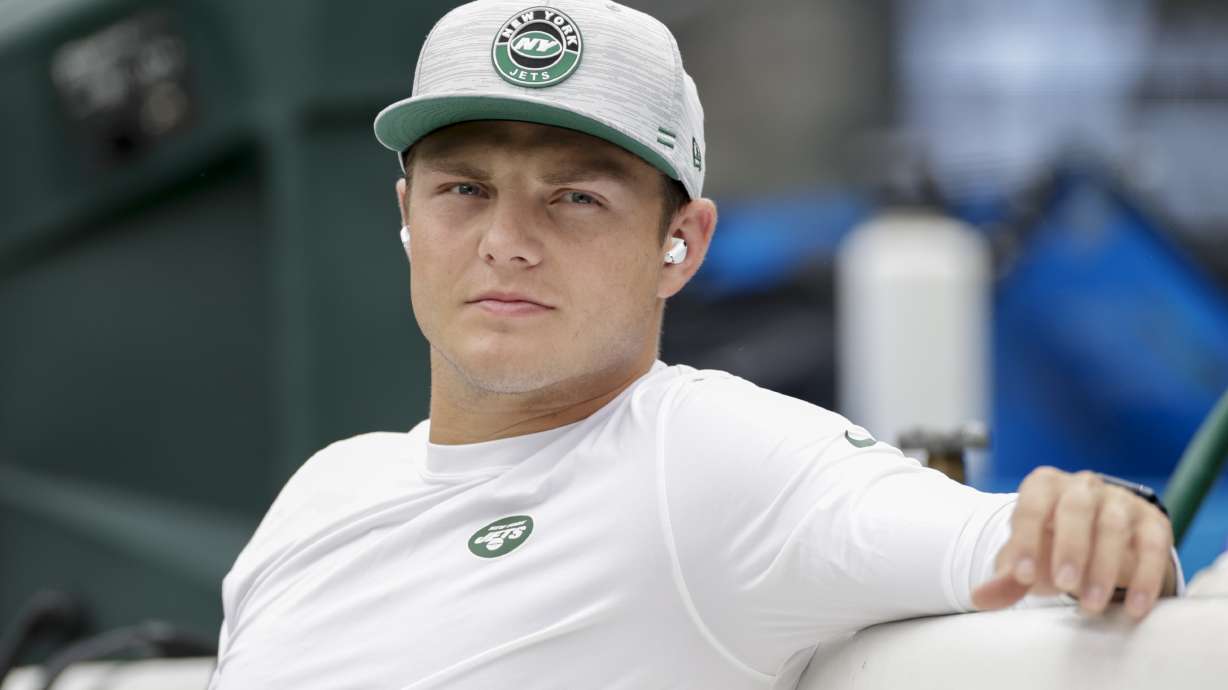 New York Jets quarterback Zach Wilson sits on the bench during practice before a preseason NFL football game against the New York Giants, Sunday, Aug. 28, 2022, in East Rutherford, N.J.