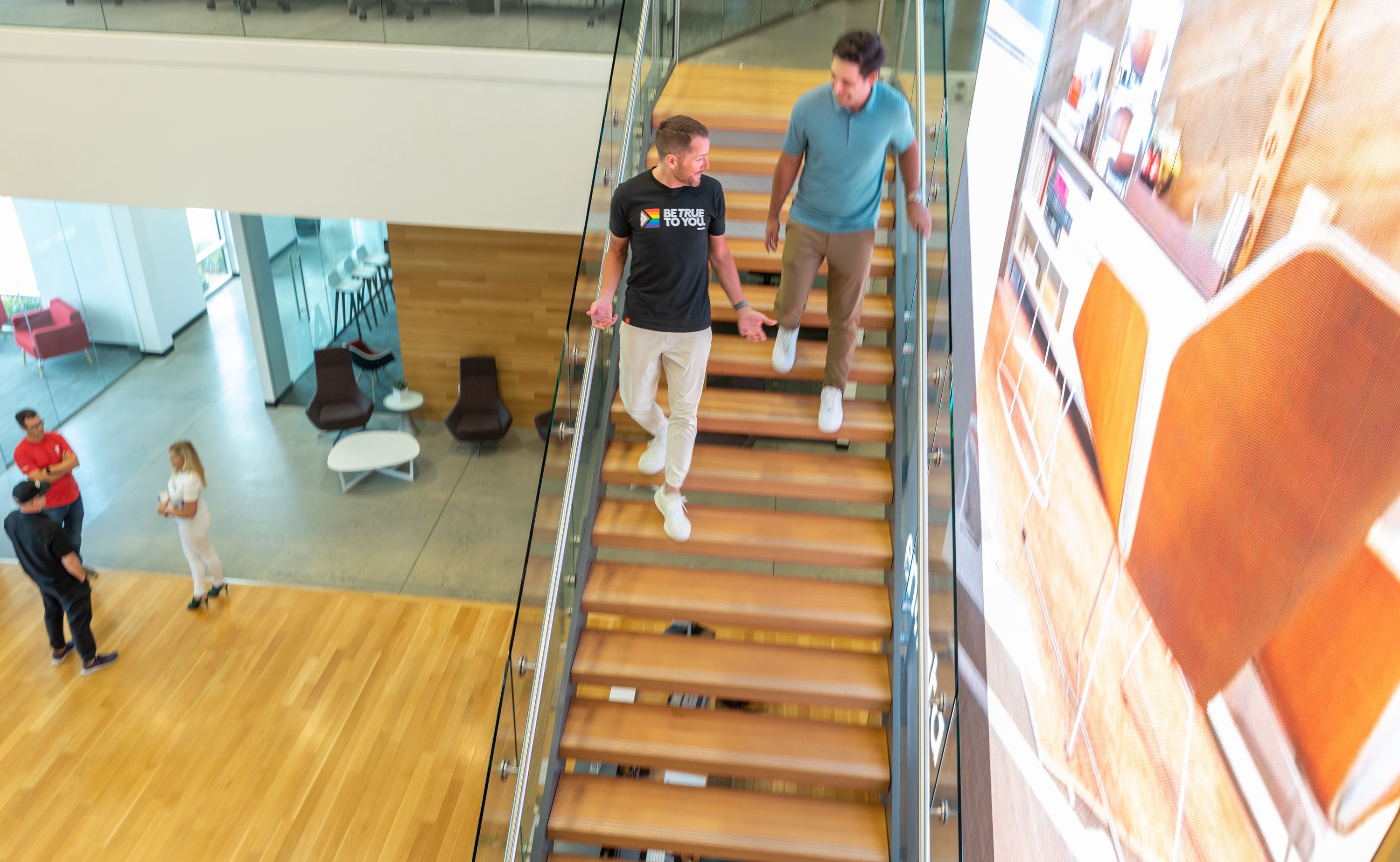 Adam Edmunds, CEO of Entrata, left, walk down a staircase with Nico Dato, Entrata’s chief marketing officer, at the company’s headquarters in Lehi on Aug. 12.