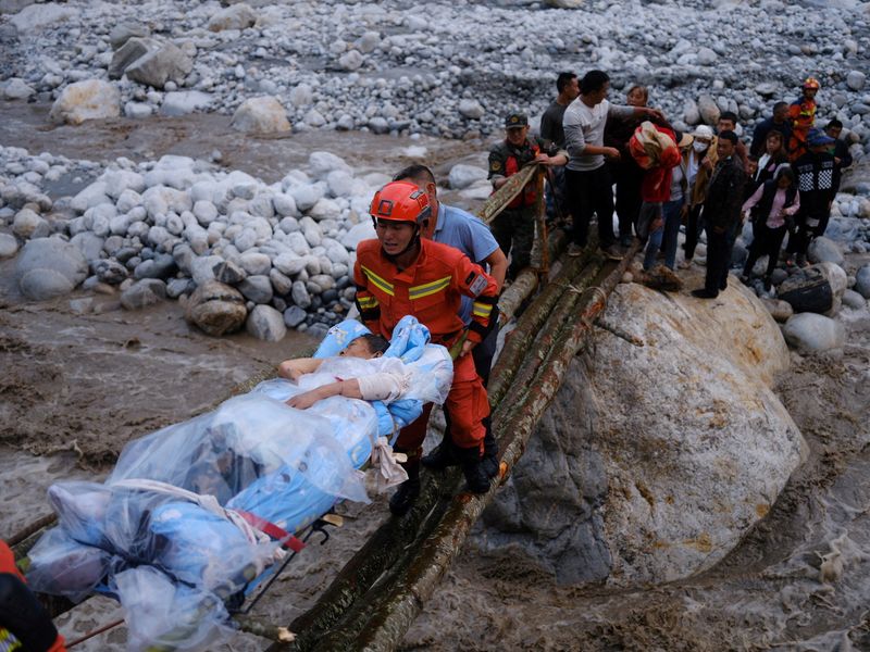 Rescue workers carry an injured victim on a stretcher following a 6.8-magnitude earthquake in Qinggangping village, Luding county, Ganzi Tibetan Autonomous Prefecture, Sichuan province, China, Monday.