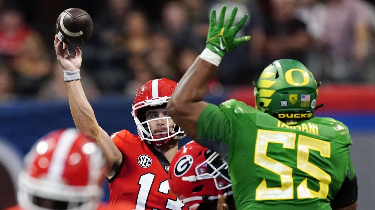 Georgia quarterback Stetson Bennett (13) throws under pressure from Oregon defensive lineman Taki Taimani (55) in the first half of an NCAA college football game Saturday, Sept. 3, 2022, in Atlanta.