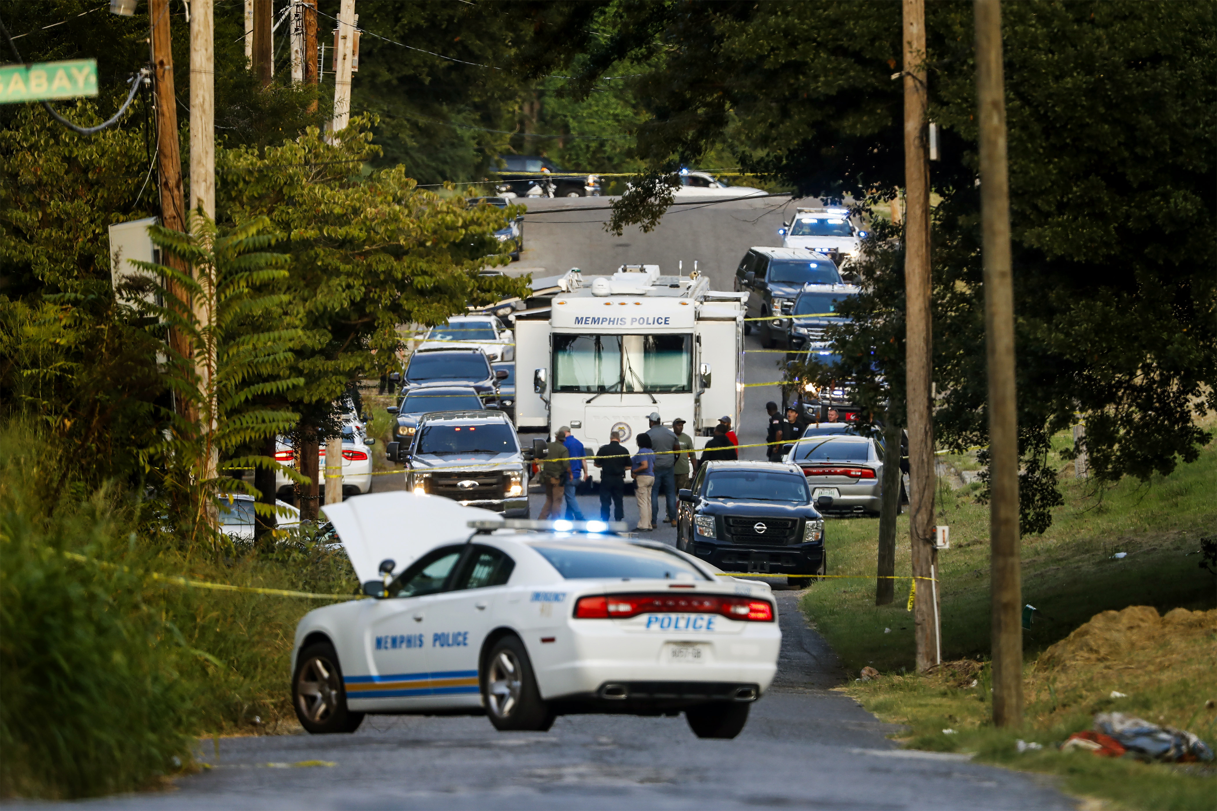 Memphis police officers search an area where a body was found in South Memphis, Tenn., Monday. Police said Tuesday that the body found during an exhaustive search is a woman who was abducted and forced into an SUV during an early morning jog. 