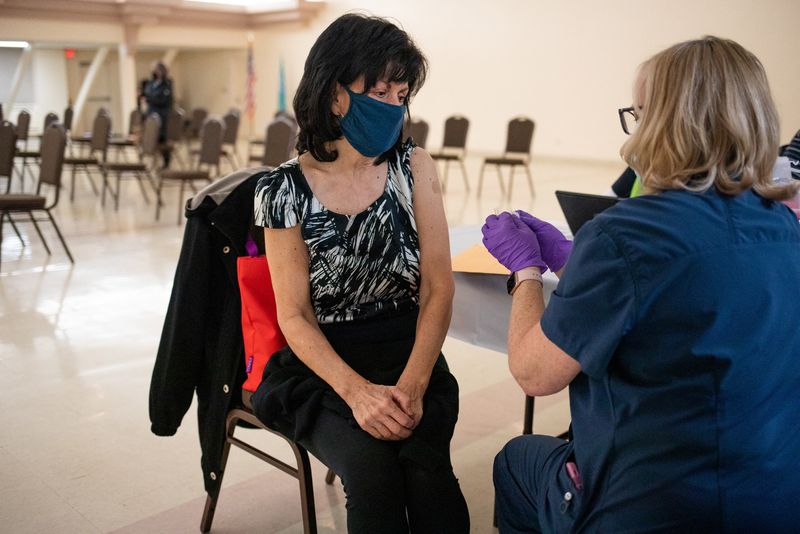 A resident that is 50 years old converses with the nurse after receiving a second booster shot of the coronavirus disease vaccine in Waterford, Michigan, April 8. New COVID-19 boosters aimed at fighting currently circulating variants of the coronavirus will be widely available this week, U.S. health officials said on Tuesday, adding that the vaccine is moving closer to an annual jab, as with flu shots.