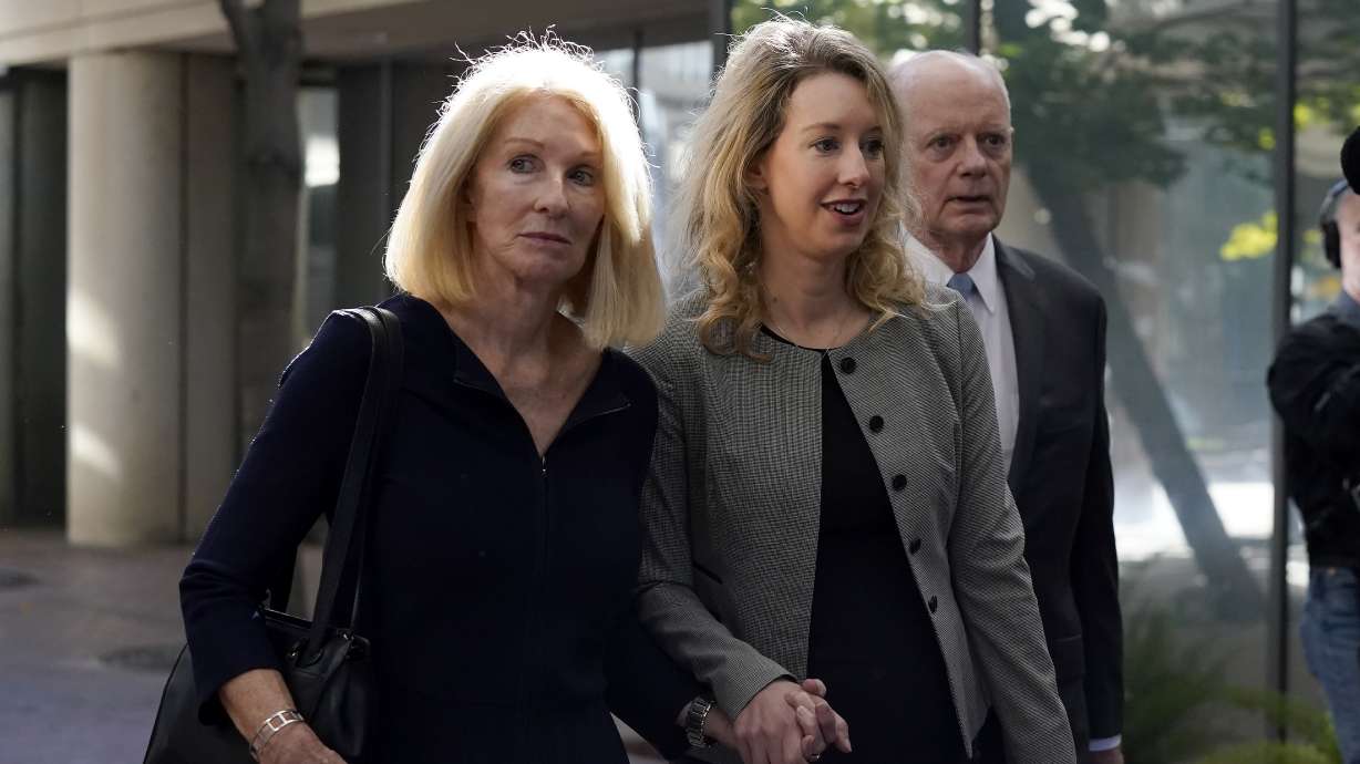 Former Theranos CEO Elizabeth Holmes, center, her mother, Noel Holmes, left, and father, Christian Holmes IV, arrive at federal court in San Jose, Calif., Thursday. Elizabeth Holmes on Tuesday requested a new trial in documents asserting that a key witness who testified against her now regrets the role he played in her criminal conviction for lying to investors about the flaws in a blood-testing technology that she had hailed as a medical breakthrough.