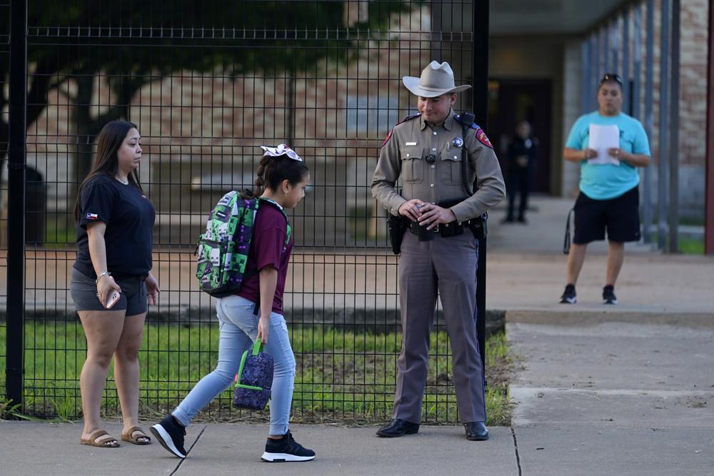 Students arrive at Uvalde Elementary, now protected by a fence and Texas State Troopers, for the first day of school, Tuesday, in Uvalde. Students in Uvalde are returning to campuses for the first time since the shootings at Robb Elementary where two teachers and 19 students were killed.