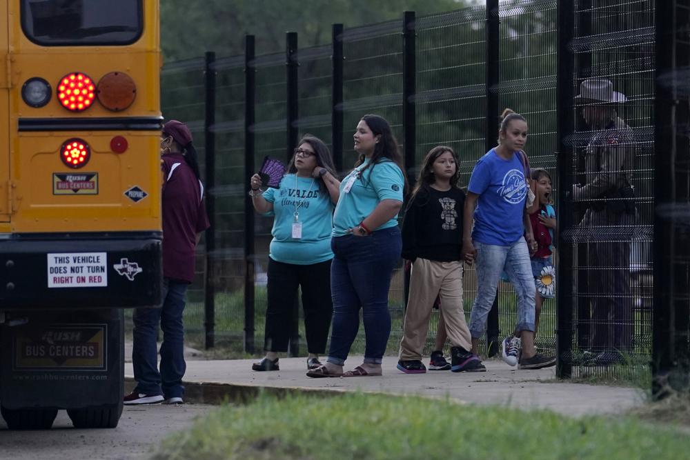 Students arrive at Uvalde Elementary for the first day of school as workers continue construction on a new fence, Tuesday, in Uvalde. Students are returning to campuses for the first time since the shootings at Robb Elementary where two teachers and 19 students were killed.